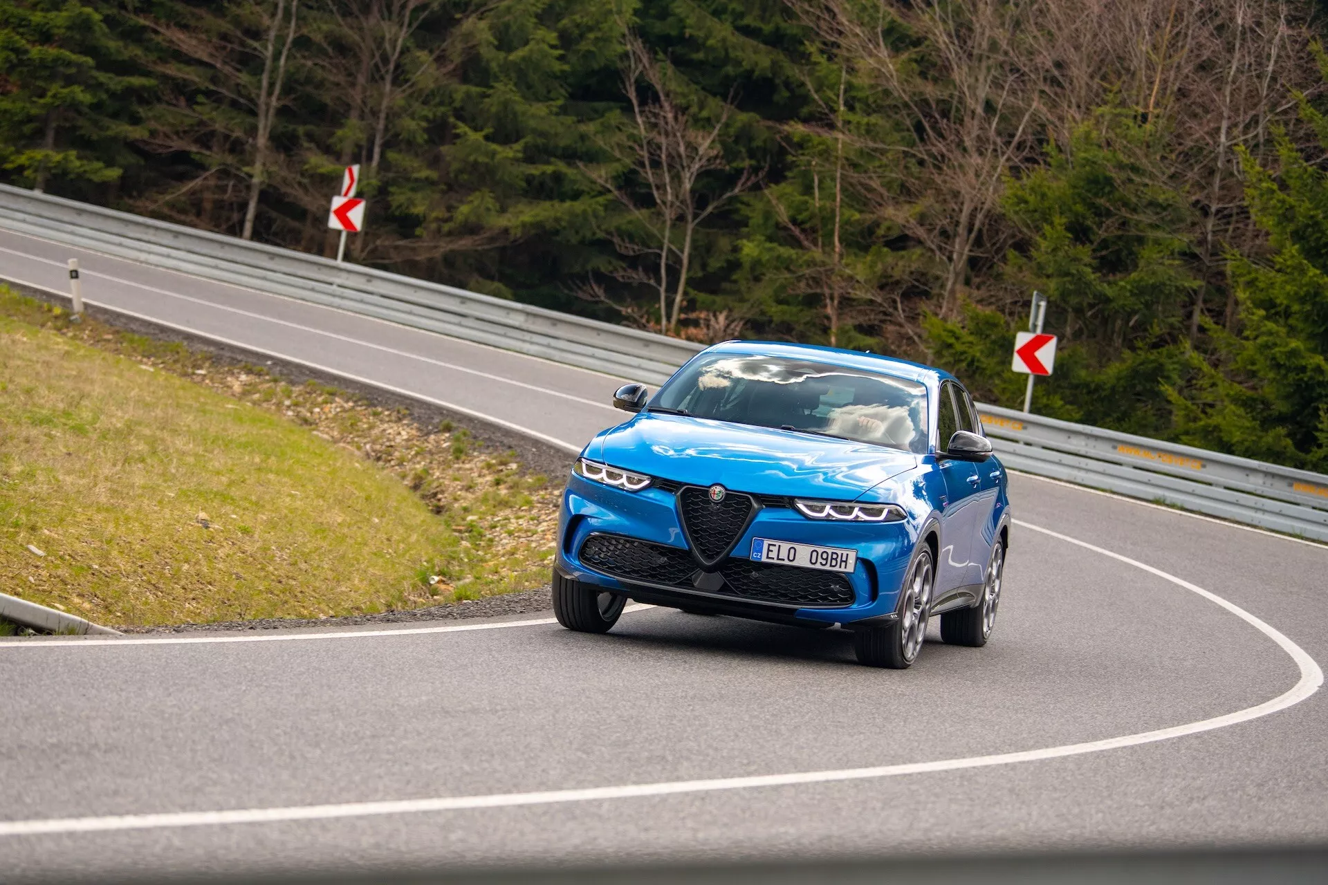 Dinamična vožnja Alfa Romeo Tonale 2022 po ovinkasti cesti, ki prikazuje pogled na prednji del, LED žaromete, značilno masko in zmogljiva kolesa