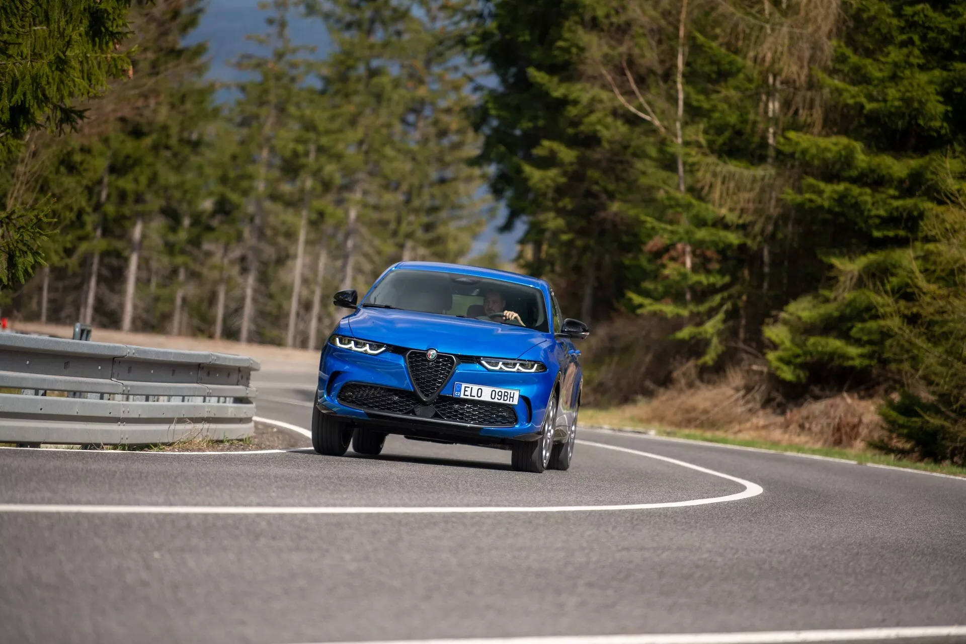 Alfa-Romeo Tonale 2022 v gibanju na ovinku ceste, ki prikazuje dinamično obliko, LED žaromete, zračnike, športni kabriolet slog in luksuzne lastnosti iz nizkega kota spredaj s treh četrtinski pogled