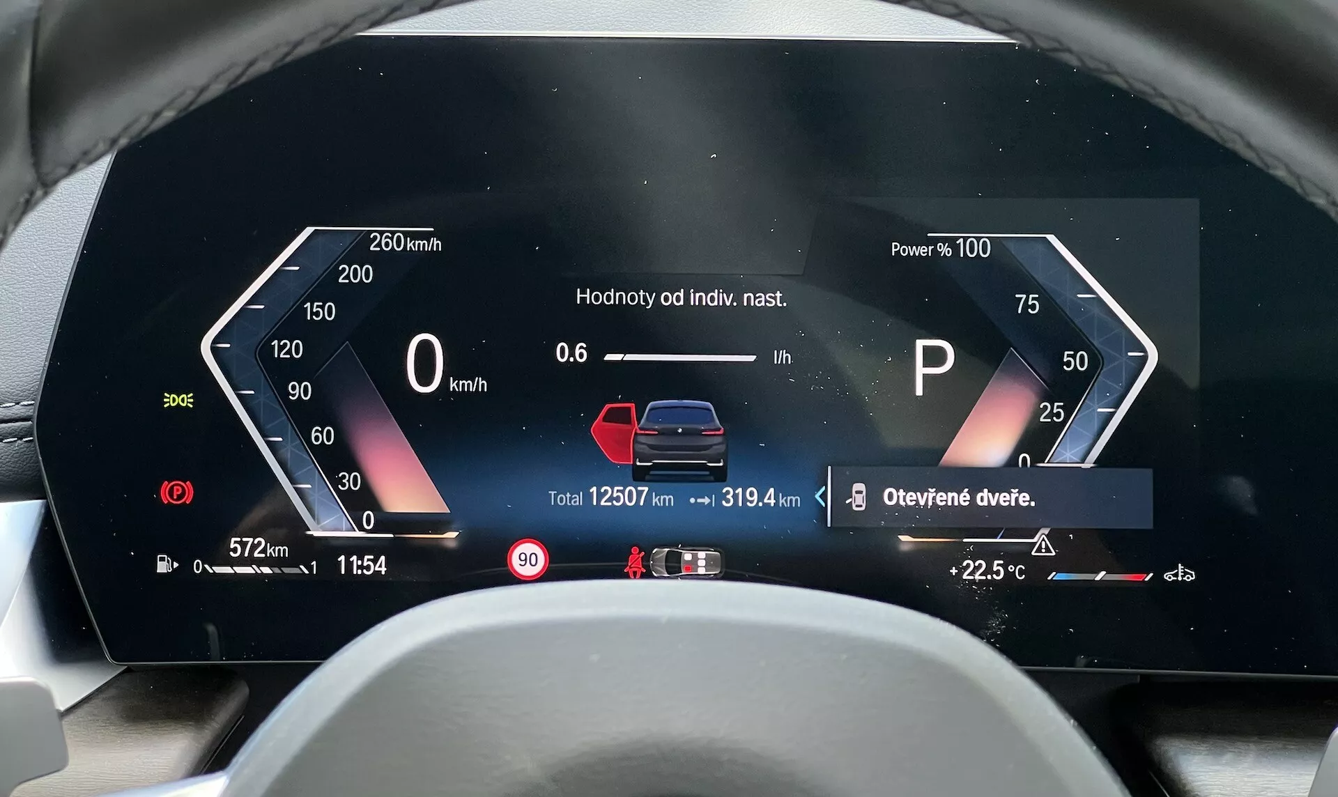 Digitalna armaturna plošča BMW serije 2 Active Gran Tourer 2022 prikazuje Hitrostomer, Porabo moči, Kazalnik izbire prestav, Grafiko stanja vozila, Števec poti, Skupni kilometromer, Zunanjo temperaturo, Opozorilne obvestila, Čas, Notranjo temperaturo in Merilnik goriva iz perspektive voznika v češčini ali slovaščini