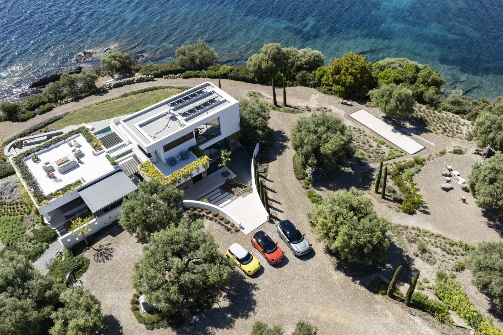 Mini Aceman 2024 (JO5) v živahni zeleni, parkiran na mestni ulici, prikazuje elegantno oblikovanje in inovativne funkcije