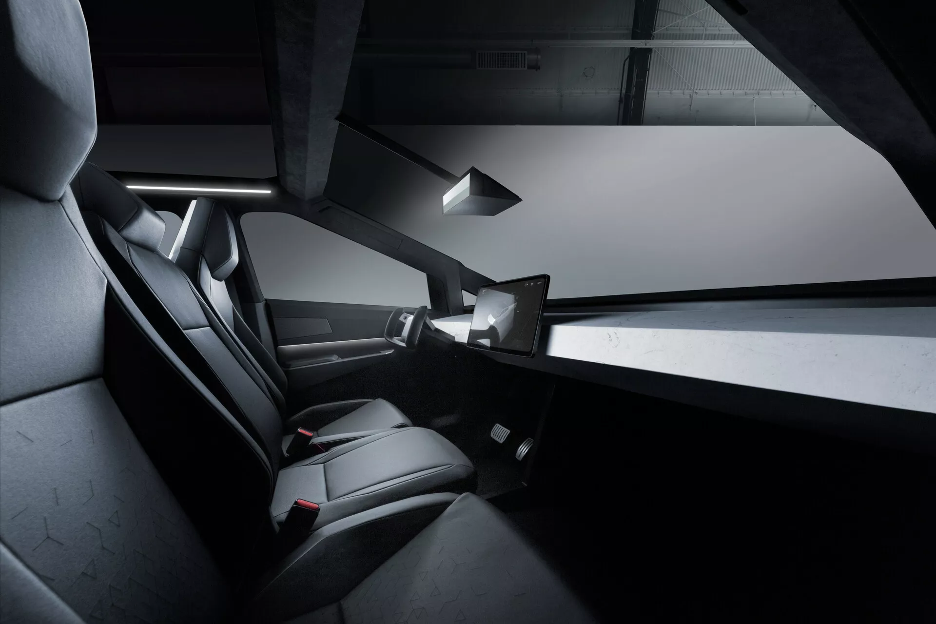 Notranji pogled na Tesla Cybertruck 2021, osredotočen na zadnji potniški prostor. Sliko izpostavljajo elegantni črni, verjetno usnjeni sedeži za dva s poudarkom na udobju in oblikovanju, delno vidni brezokvirni okni vrat, vitka sredinska konzola, zgornja notranja luč in zadnja nameščena plošča na dotik. Oblikovanje je minimalistično z ostrimi linijami in enobarvno zasnovo.