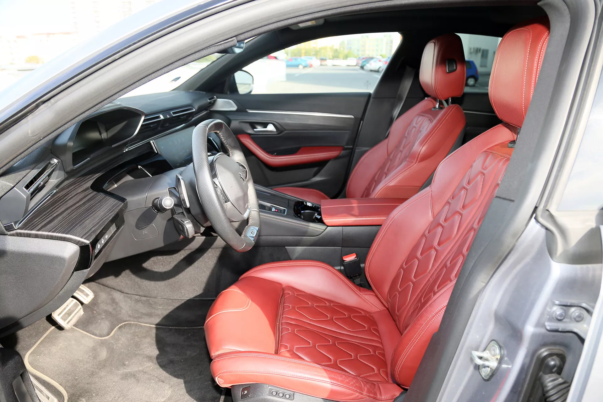 Notranji pogled Toyote Camry Limuzine 2001 z voznikove strani, ki prikazuje rdeče usnjene sedeže s prešitim vzorcem, elegantno črno armaturno ploščo z integriranim zaslonom za infotainment in napredne nadzorne gumbe na volanu