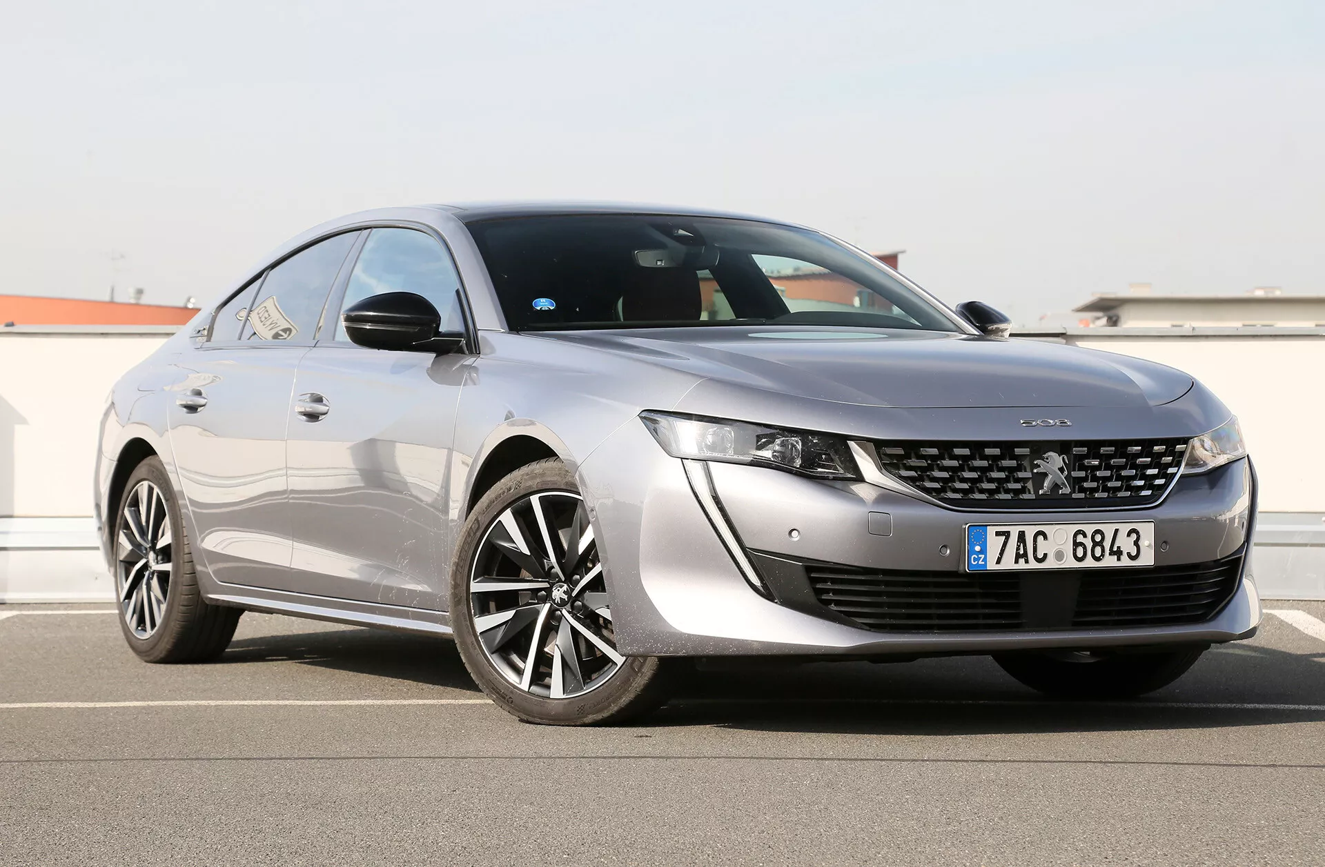 Toyota Camry Limuzina 2019, prikazana pod kotom treh četrtin spredaj, ki prikazuje njene elegantne LED žaromete, značilno sprednjo masko z osrednjim značkem, aerodinamično oblikovan pokrov motorja in stranski profil z velikimi večkrakimi legiranimi kolesi, sijočo barvo in streho podobno kupeju