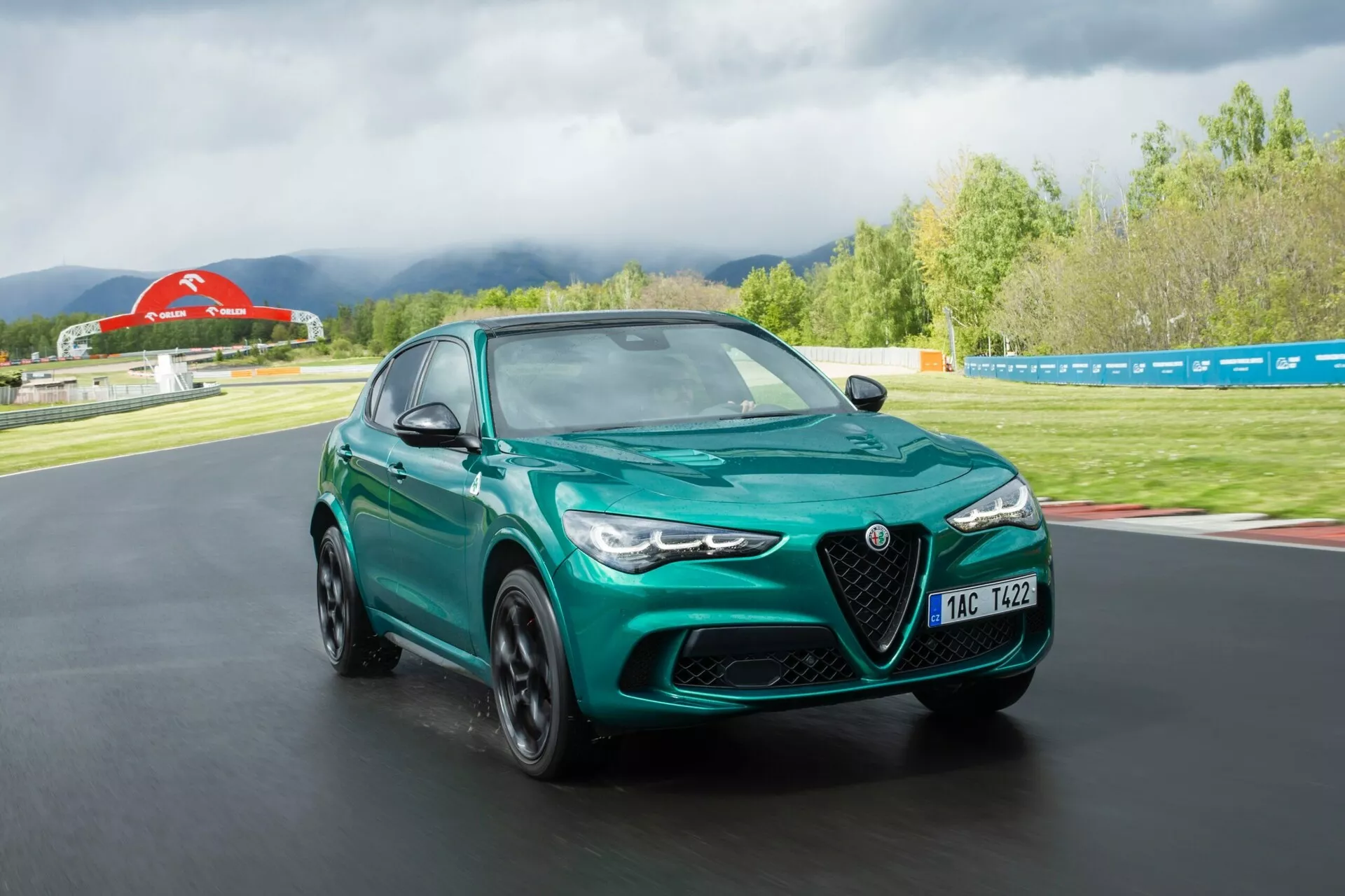 Alfa-Romeo Giulia Quadrifoglio 2023 v živahni rdeči barvi, ki prikazuje njeno elegantno zasnovo, napredno aerodinamiko in močno držo