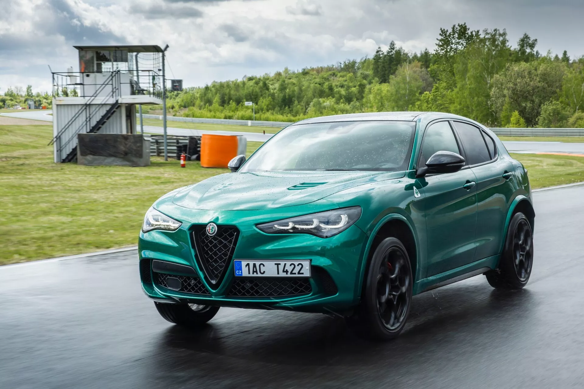 Alfa Romeo Giulia Quadrifoglio 2023 v metalik rdeči barvi prikazuje napredno aerodinamiko, elegantno oblikovanje z značilno V-oblikovano rešetko in bi-ksenonskimi žarometi