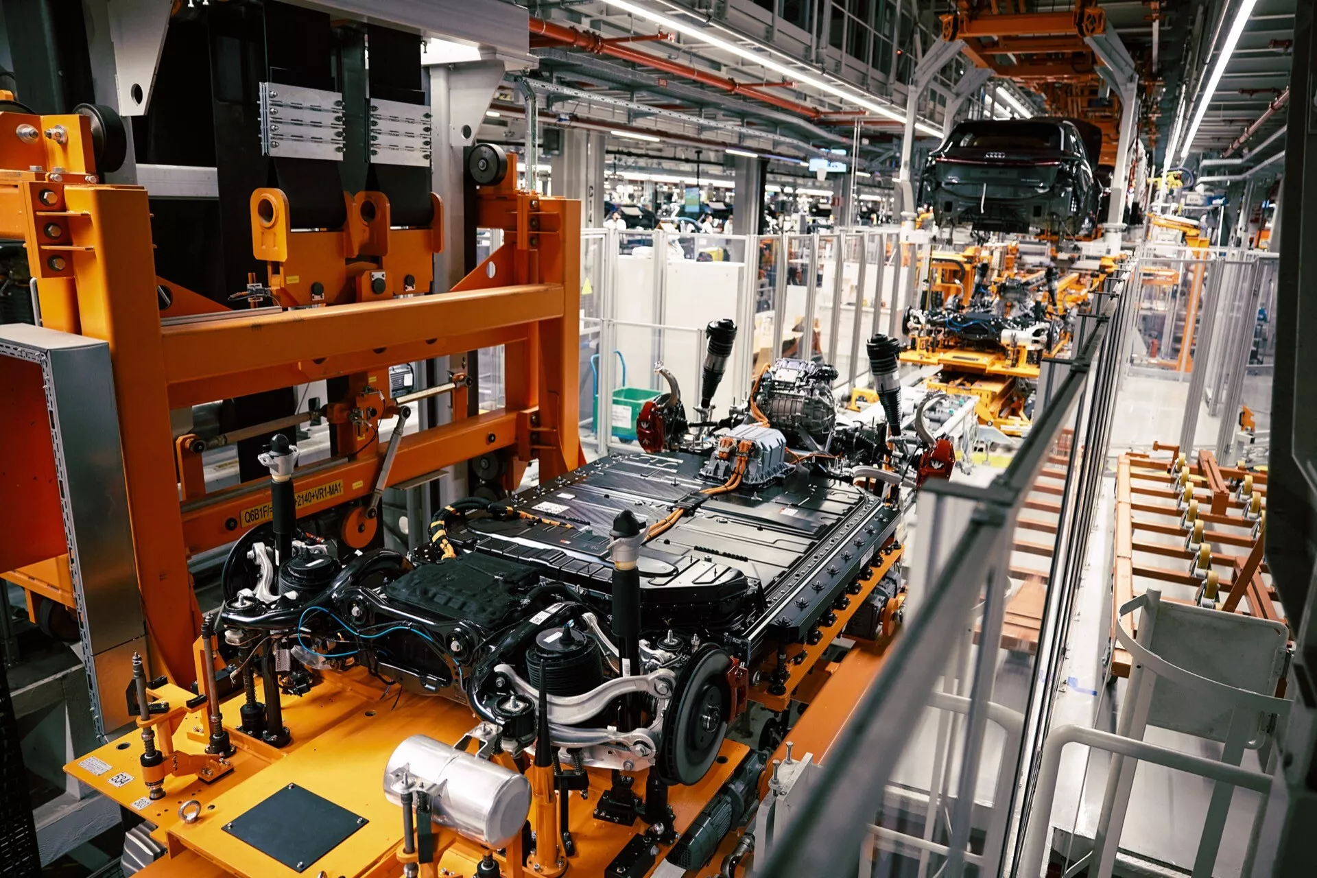 Pogled z višine na montažno linijo Audi Q8 e-tron 2023 v tovarni s šasijo avtomobila in robotsko avtomatizacijo