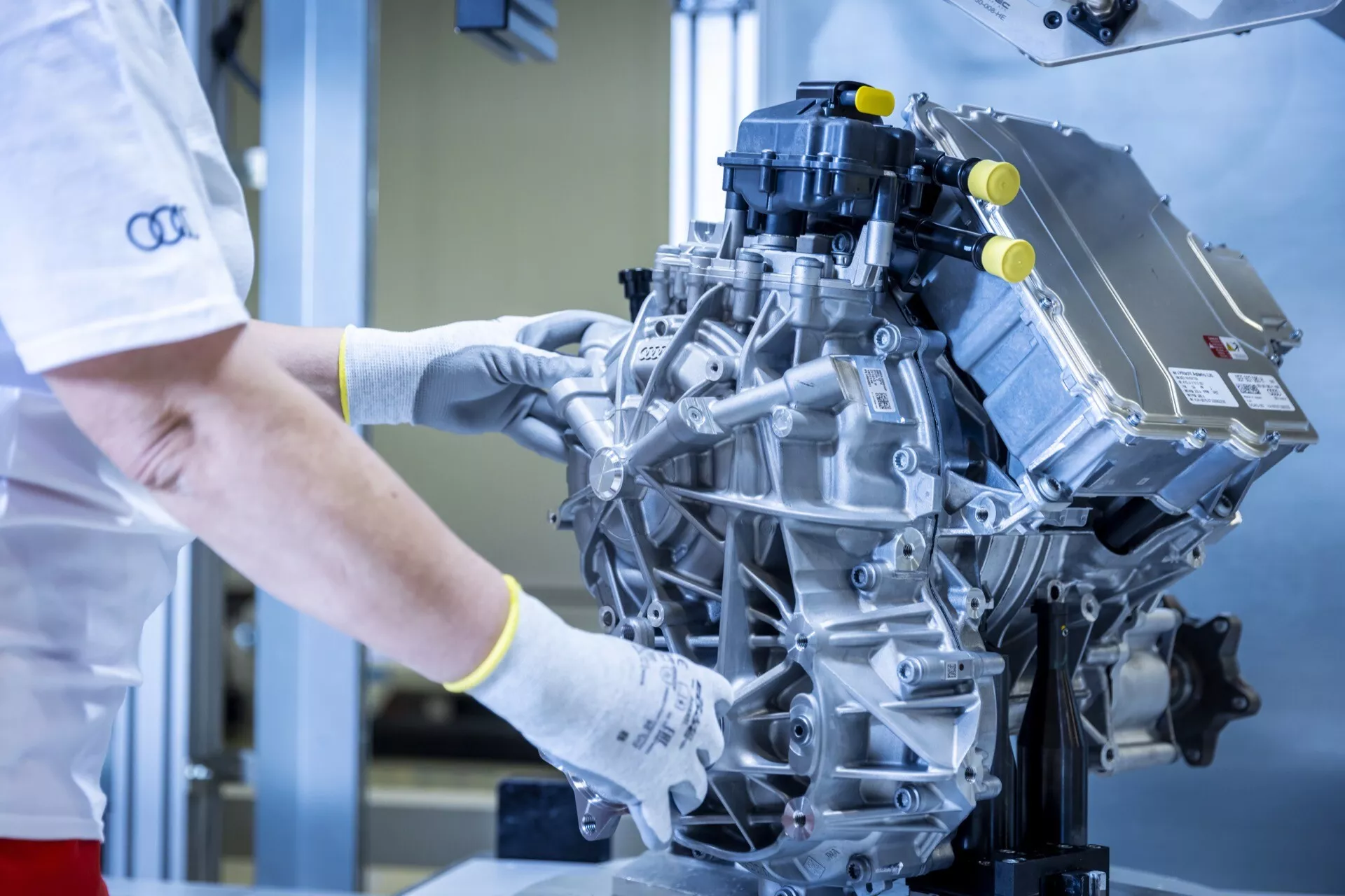 Podroben pogled na sodoben, visokozmogljiv motor, ki ga inšpektor pregleduje v čistem industrijskem okolju, pri čemer poudarja sestavne dele, kot sta sesalni kolektor in tuljave vžiga.