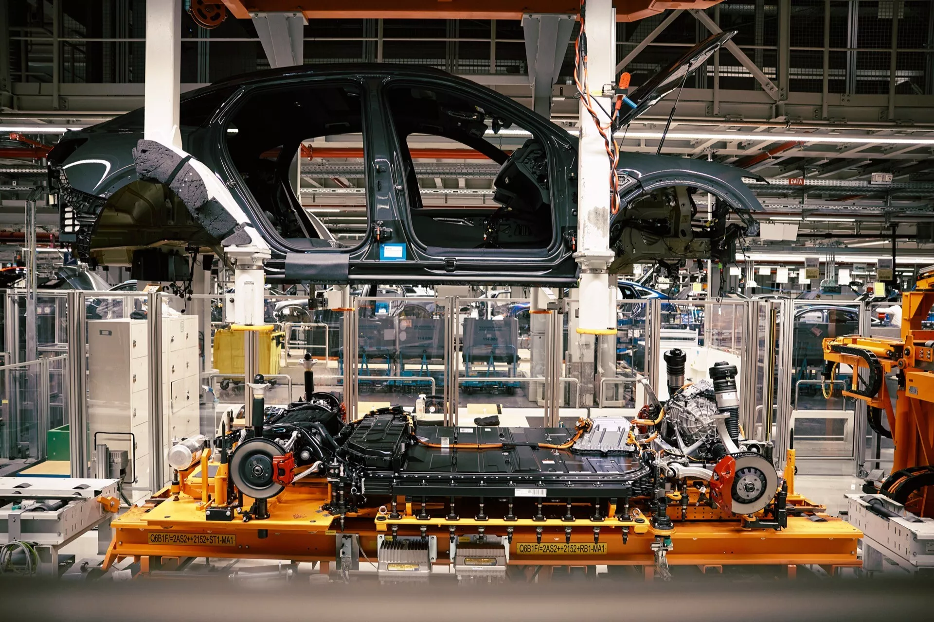 Delno sestavljeno Audi Q8 e-tron 2023 na proizvodni liniji, ki prikazuje šasijo in namestitev motorja v avtomobilski tovarni
