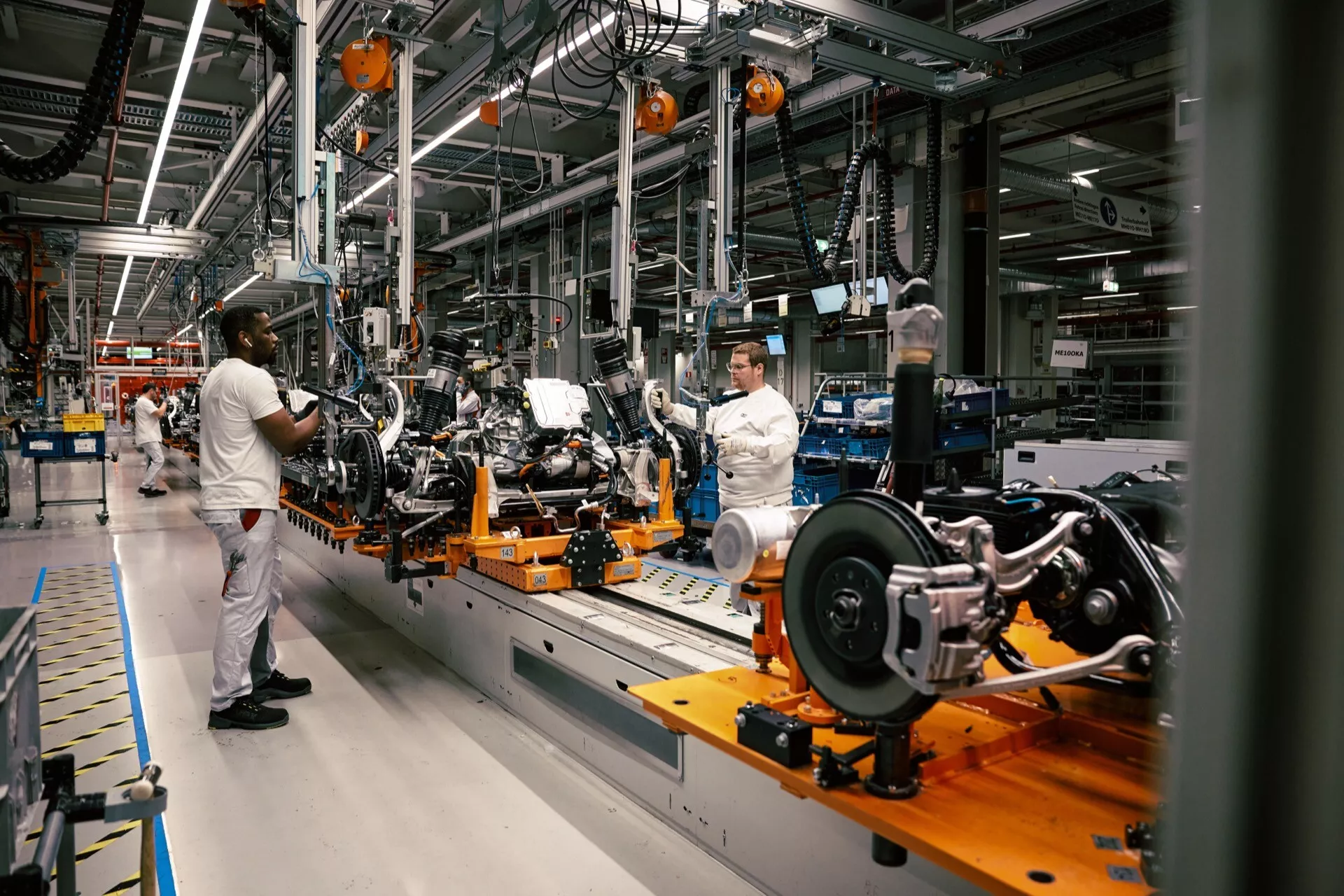 Šasija Audi Q8 e-tron 2023 na montažni liniji v proizvodnji, ki prikazuje zgodnjo fazo gradnje, zadnji vzmetni sistem in tehnologijo proizvodne linije