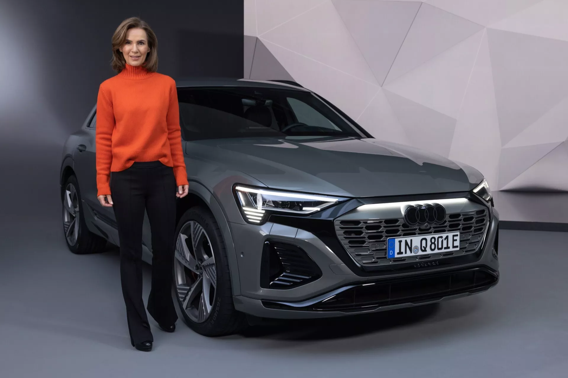 Sprednji kotni pogled na Audi Q8 e-tron 2023 z LED žarometi, šesterokotno sprednjo rešetko in elegantnimi oblikovnimi linijami