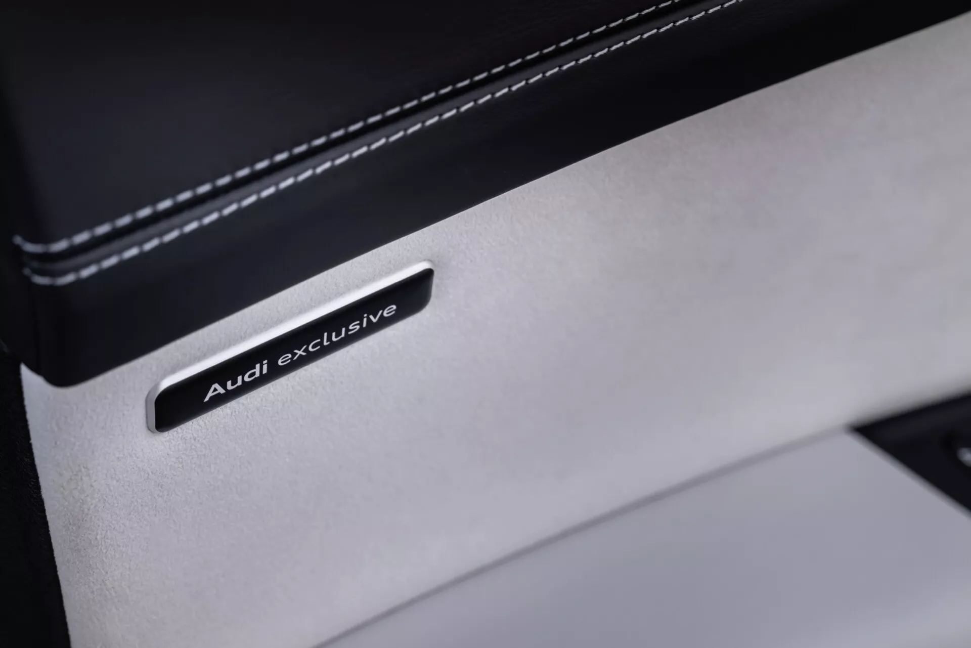Posnetek od blizu značke Audi exclusive na detajlu iz premium usnja v notranjosti Audi Q8 2023 (4M-Facelift), ki prikazuje luksuzno prilagoditev in kakovost materiala