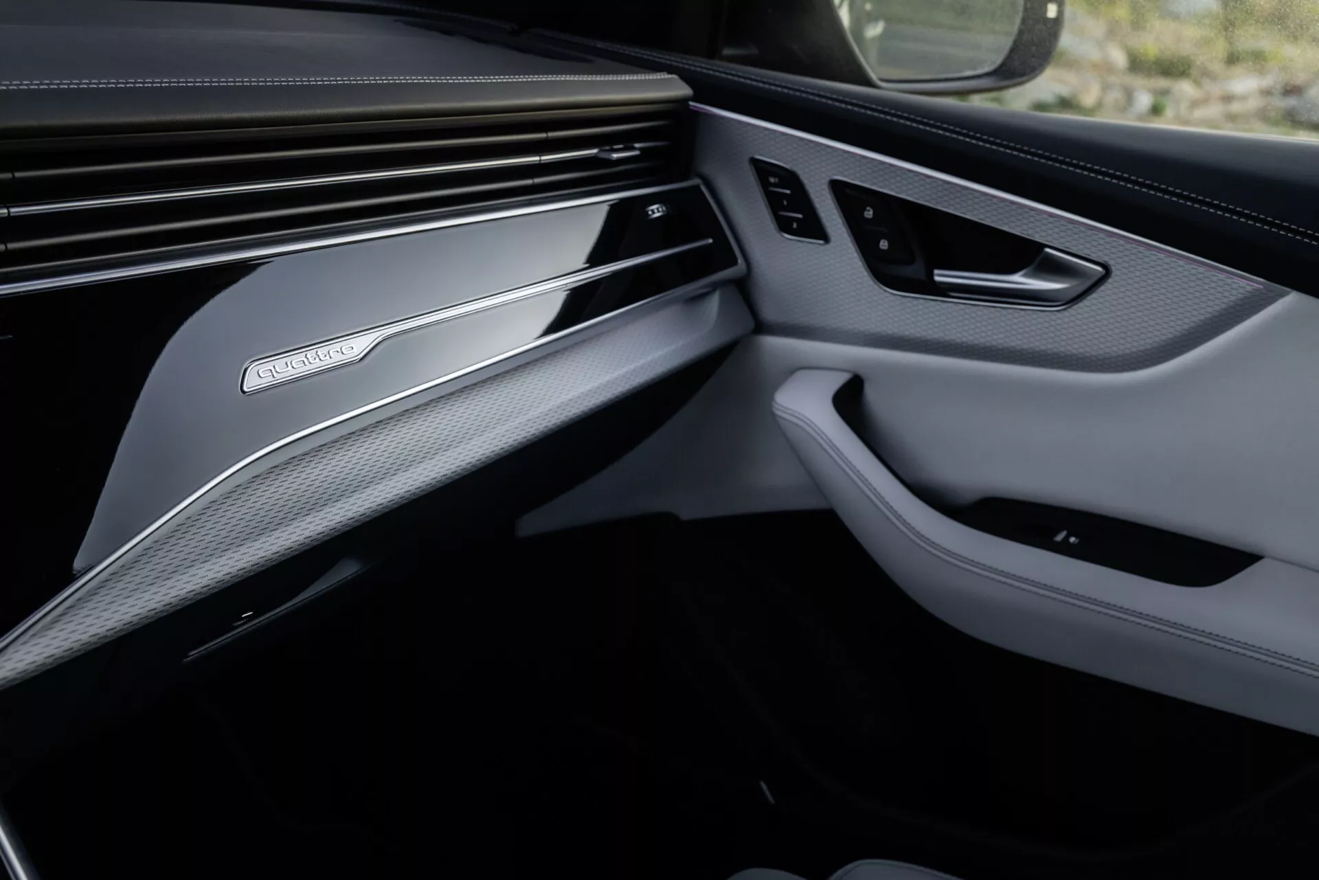 Notranji posnetek Audi Q8 2023 (4M-Facelift) osredotočen na razkošno zasnovo prednjega sovoznikovega dela, vključno z detajlnim pogledom na armaturno ploščo in ploščo vrat z vrhunskimi materiali in tehnološkimi funkcijami