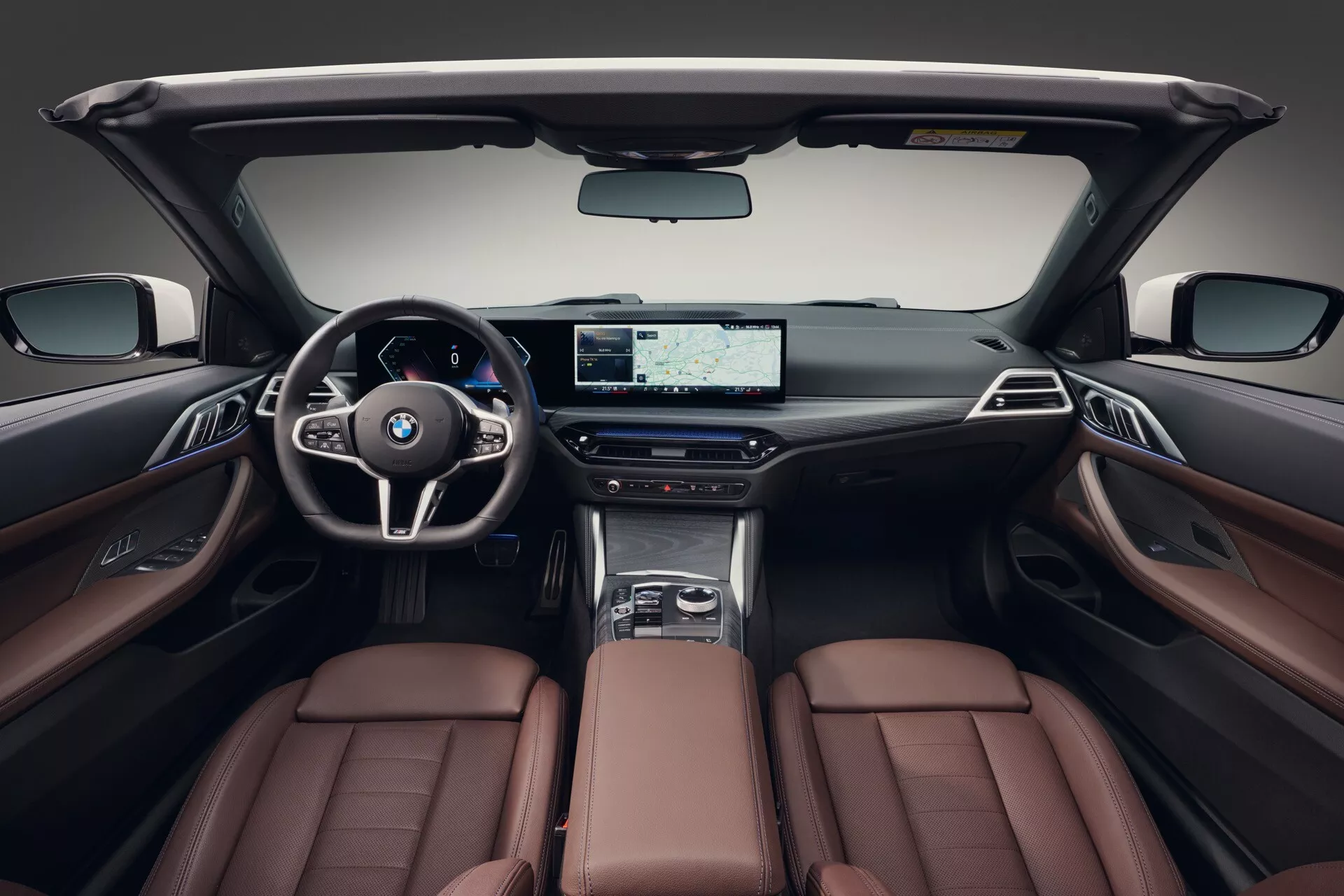 Notranjost BMW serije 4 za leto 2024 (G22-G23-G26-G82-G83 Facelift) z razkošnimi rjavimi usnjenimi sedeži, sodobno armaturno ploščo z širokozaslonskim zaslonom in športnim volanom, ki poudarjajo premijske funkcije in dizajn kabine.
