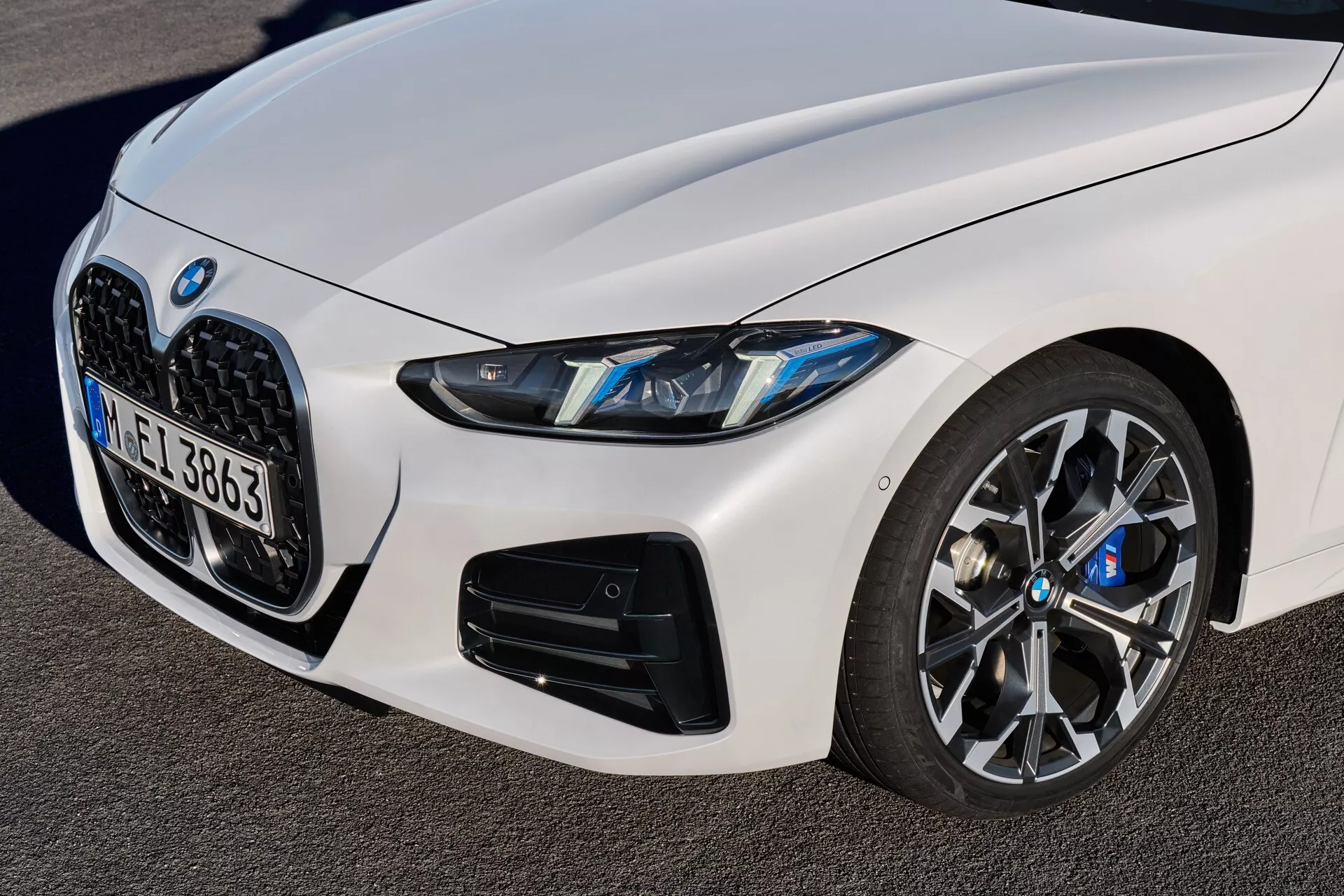 Podroben pogled na BMW serije 4 2024 (G22-G23-G26-G82-G83 prenova) prikazuje čelni levi kvadrant, z ledvičasto oblikovano rešetko, LED žarometi, veliki zračniki na spodnjem odbijaču, namenjeni zmogljivostim, in večkraka kolesa z naprednim zavornim sistemom, vse iz nizkega, navzgor usmerjenega kota, ki poudarja športne in luksuzne oblikovalske elemente avtomobila.