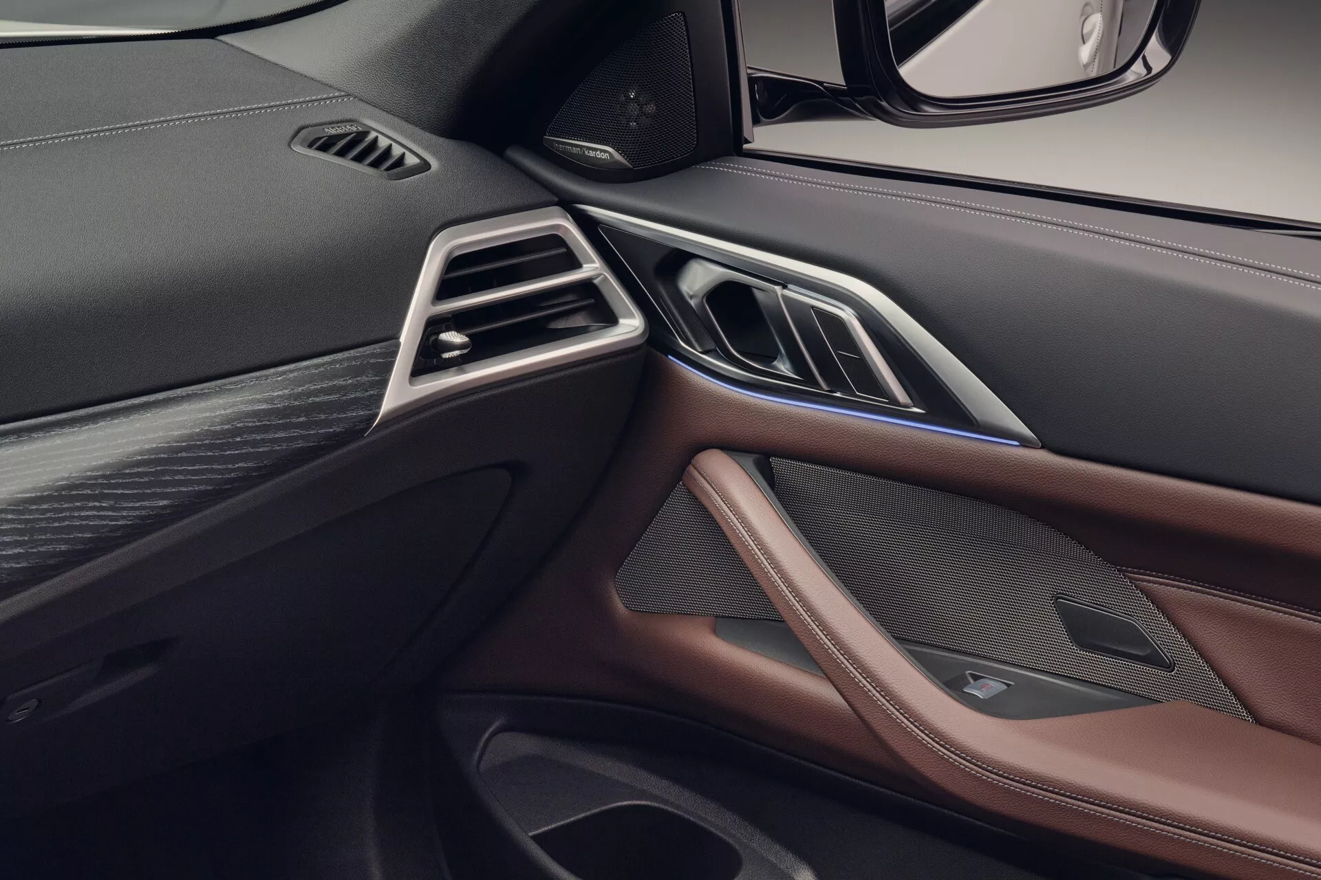 Podroben pogled na armaturno ploščo sprednjega sovoznikovega dela desne volanske ureditve BMW serije 4 2024 (G22-G23-G26-G82-G83-Facelift), ki prikazuje zračnike, luksuzne materiale in integrirane kontrole.