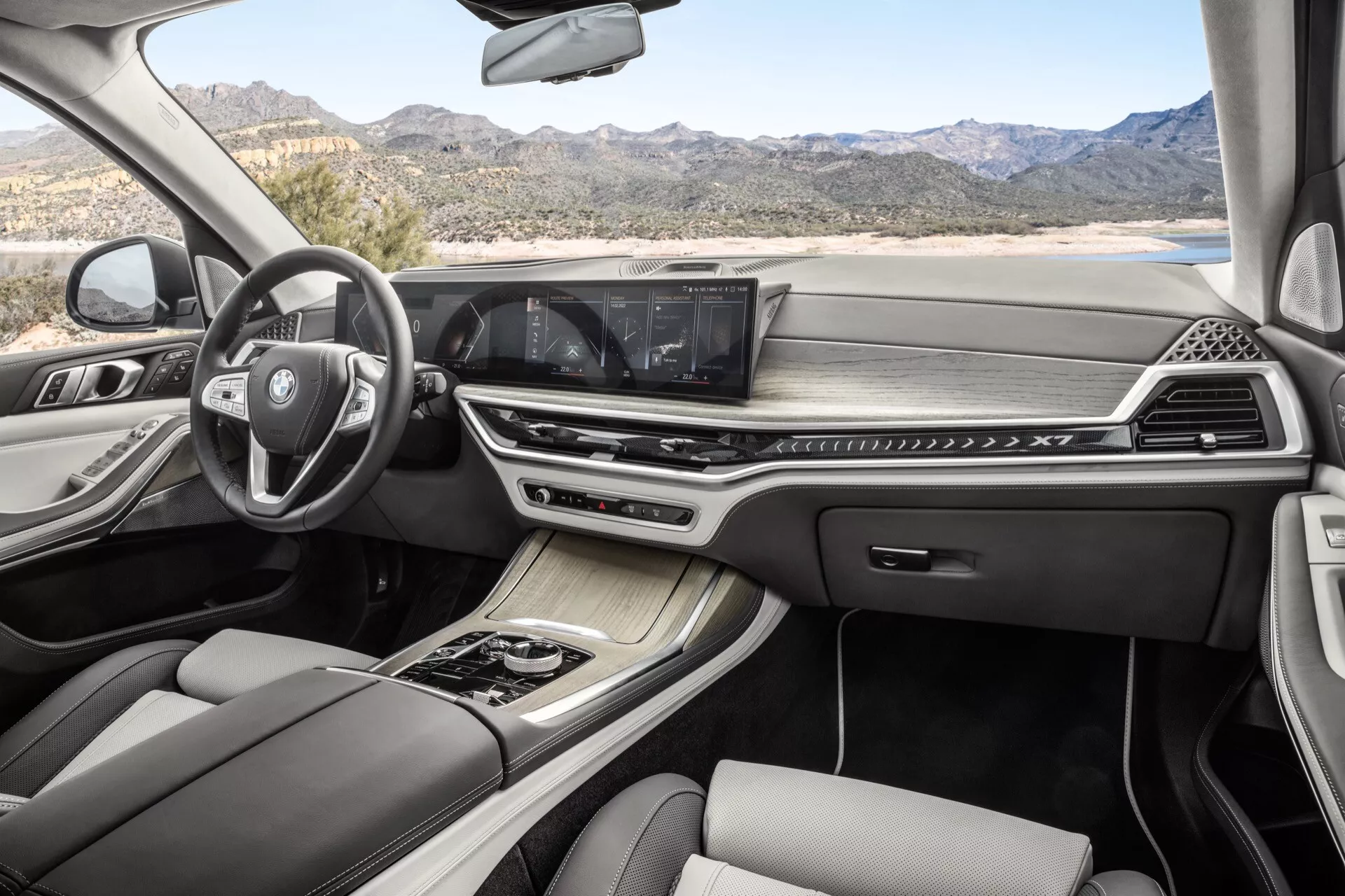 Notranjost BMW X7 2022 (G07-facelift) z multifunkcijskim volanom, naprednim informacijsko-razvedrilnim sistemom z zaslonom na dotik, dvopodročno klimatsko napravo, elegantno avtomatsko prestavno ročico, luksuznimi usnjenimi sedeži s kontrastnim šivanjem in panoramsko streho