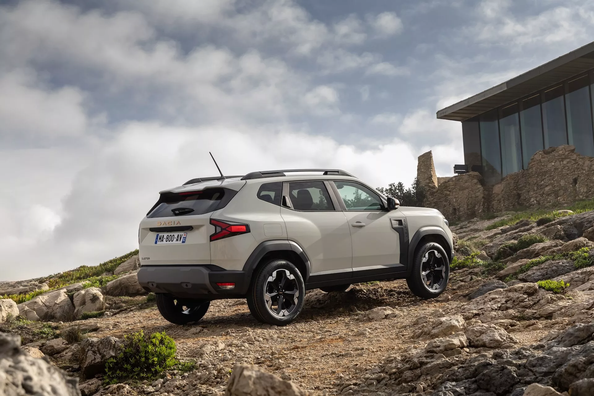 Dacia Duster tretje generacije 2024 v dinamični pozi prikazuje nov dizajn in funkcije