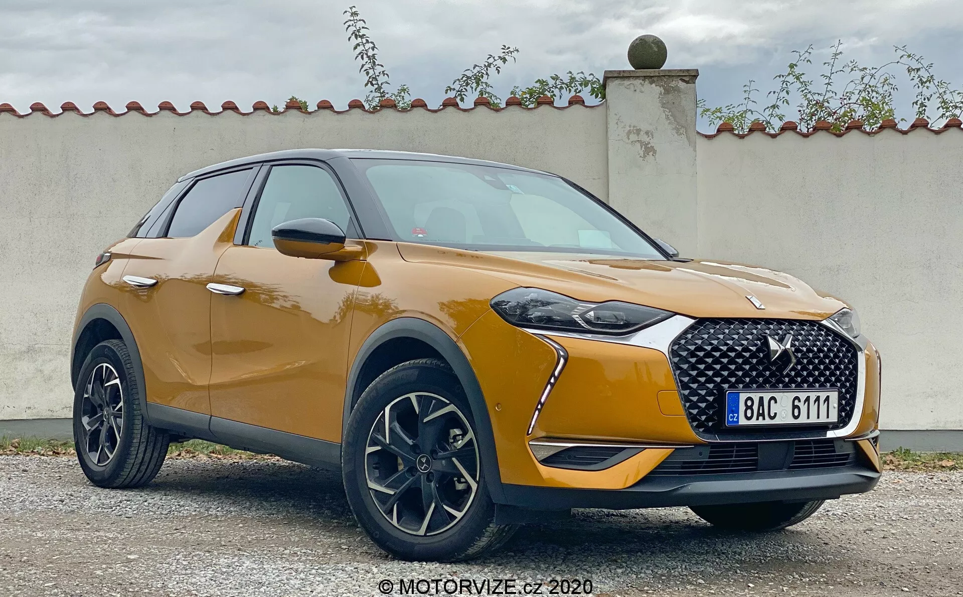 Spredajnj anal de treh četrtin modela DS Automobiles DS 3 Crossback 2019. Slika prikazuje sodoben crossover SUV z značilno masko, elegantnimi LED žarometi in ohišji za meglenke. Kovinska barva, gladko oblikovana kapuca in lita platišča poudarjajo športno, a prefinjeno zasnovo. Aerodinamično oblikovana ogledala s vgrajenimi smerniki in plastična obloga okoli kolesnih lokov prispevajo k robustni estetiki vozila.