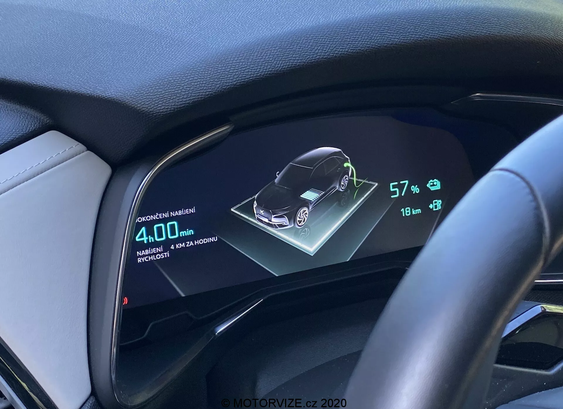 Digitalni zaslon armaturne plošče DS Automobiles DS-7 2018 (DS-7 Crossback), ki prikazuje 3D grafično predstavitev vozila, stanje baterije pri 57%, doseg 18 km in povprečno porabo goriva 4,0L/100km, iz voznikove perspektive s volanom in usnjeno ploščo.