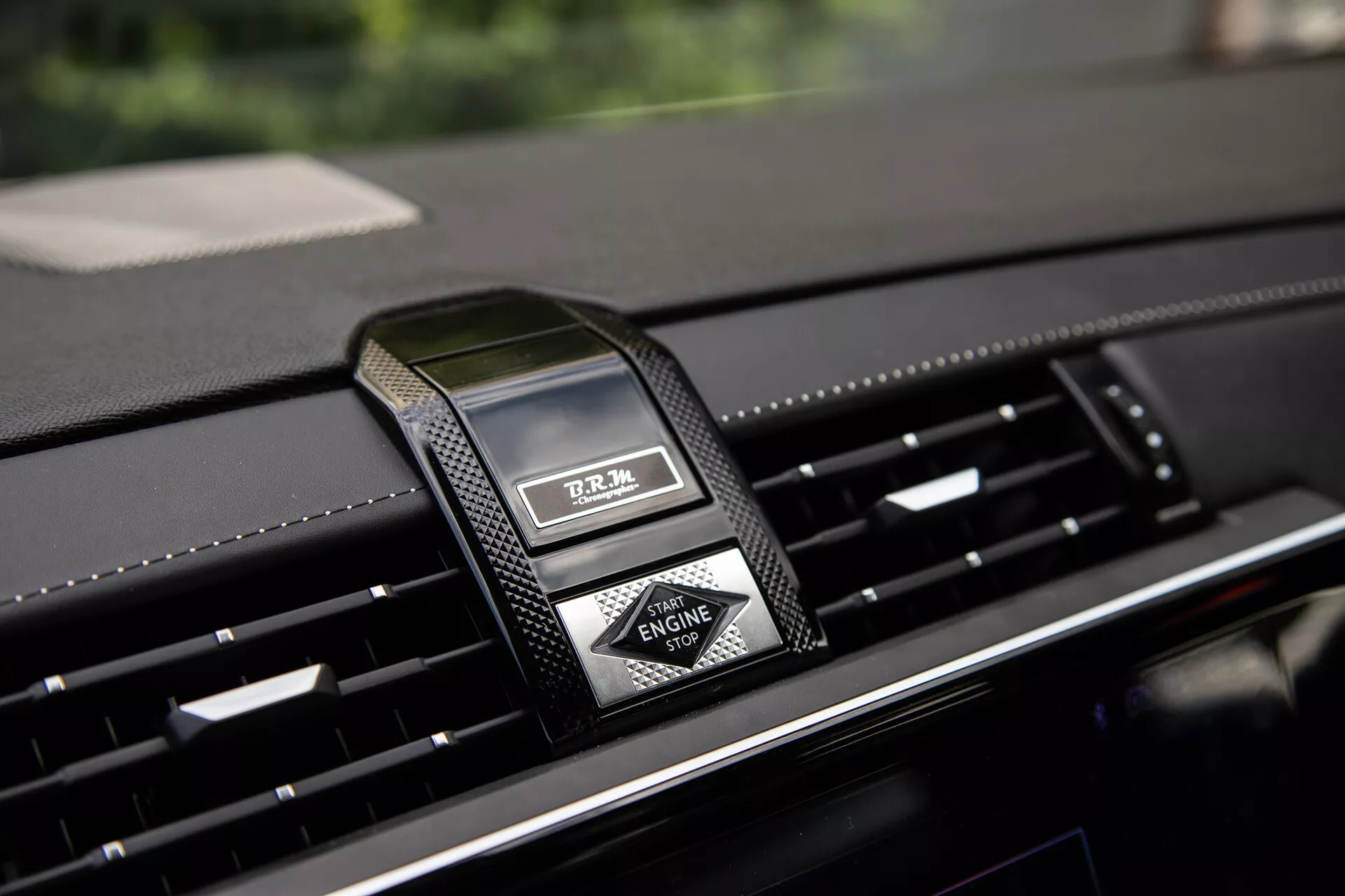 Pogled od blizu na srednji armaturni plošči DS Automobiles DS-7 2022 z luksuzno analognimi urami in prezračevalniki, ki poudarja premijske materiale in sodobno oblikovanje