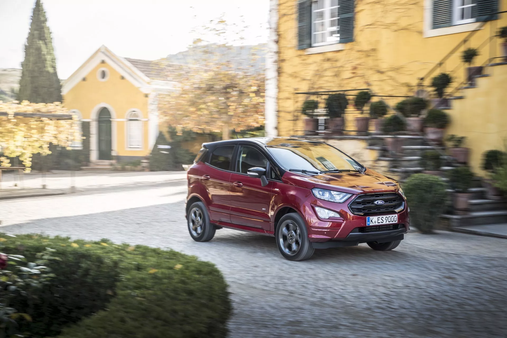 Srebrni Ford EcoSport prve generacije z leta 2017 s prenovljenim zunanjim videzom, parkiran na prostem v sončnem dnevu, ki prikazuje njegov eleganten dizajn in kompaktno karoserijo SUV