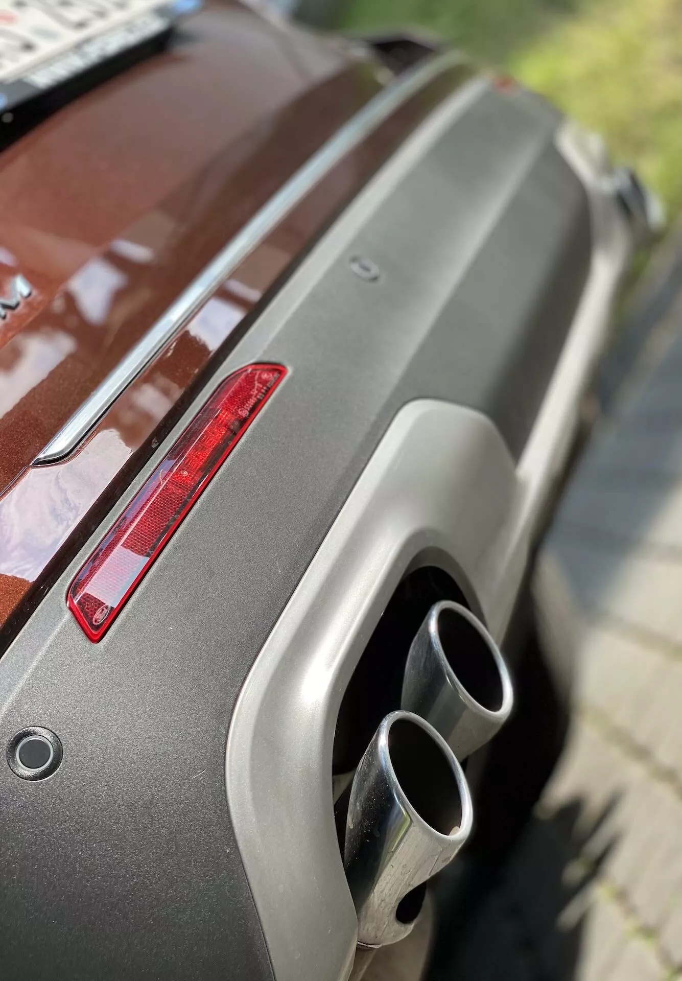Od bližnjem posnetku zadnjega dela Ford Explorer 2019, ki prikazuje kovinsko barvo, zadnji spojler, zadnjo luč rdeče barve in dvojne kromirane izpušne cevi. Poševni kot iz povišanega položaja poudarja dobro vzdrževan zaključek in moderne oblikovalske značilnosti.