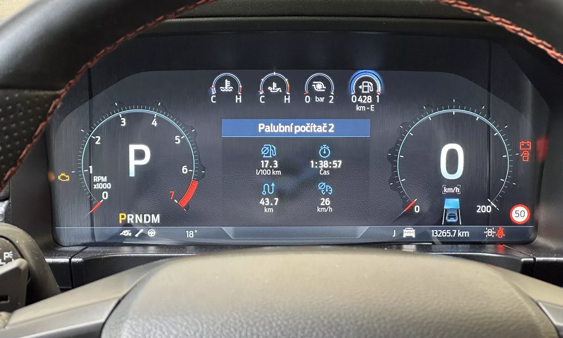 Pogled iz voznikovega sedeža na digitalno armaturno ploščo Ford Ranger 2022, ki prikazuje merilnik vrtljajev, merilnik goriva, hitrostomer, zaslon temperature in izbiro prestav na sodobni armaturni plošči vozila