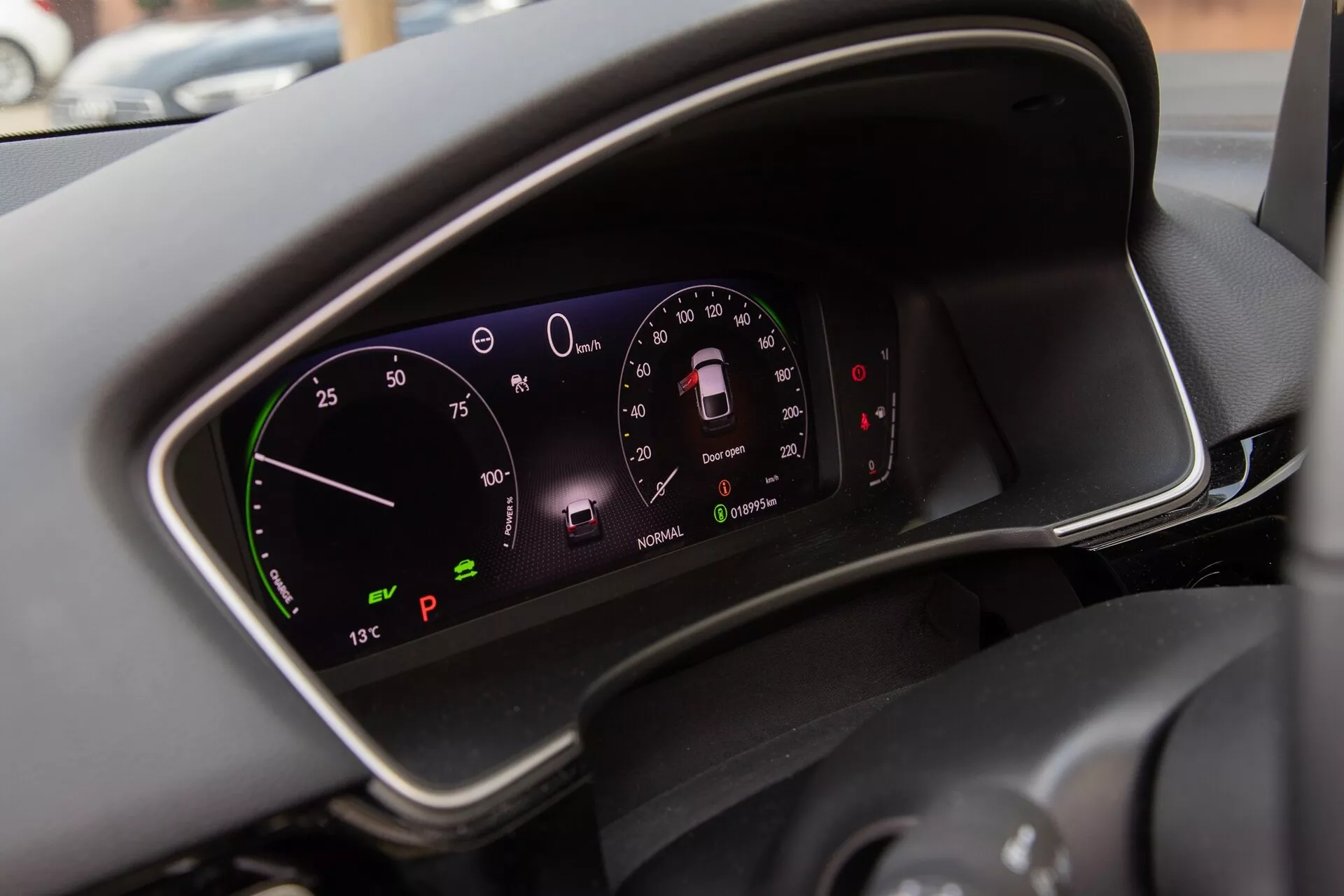 Približek digitalne instrumentne plošče Honda Civic 2022, ki prikazuje hitrostomer, tahometer, kazalnike stanja vozila in zunanjo temperaturo v napredni tehnološki notranjosti modernega avtomobila