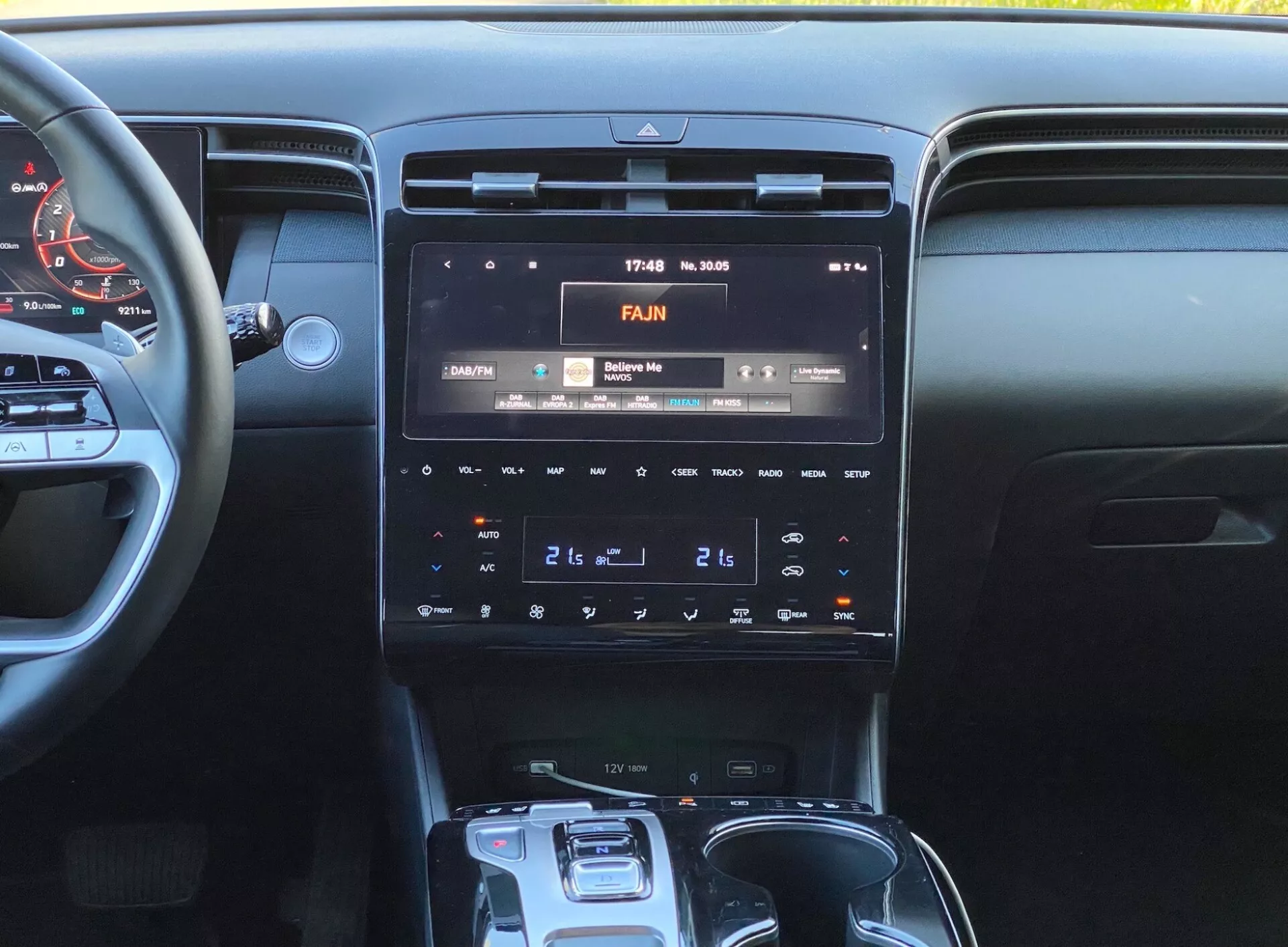 Slika notranjosti Hyundai Tucson 2020, osredotočena na sredinsko konzolo z visoko ločljivim zaslonom za informiranje in zabavo, ki prikazuje 17:43 in 30°C, panel za dvopodročno klimatsko napravo ter avtomatski selektor menjalnika.