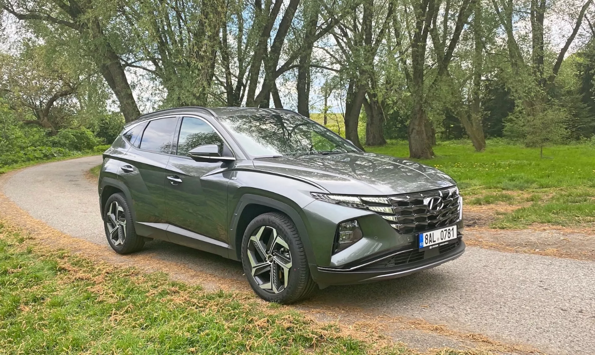 Hyundai Tucson 1.6 T-GDI Pure letnik 2020 v brezhibni beli barvi, ki prikazuje svojo elegantno obliko in sodobne funkcije na slikoviti hribski cesti.