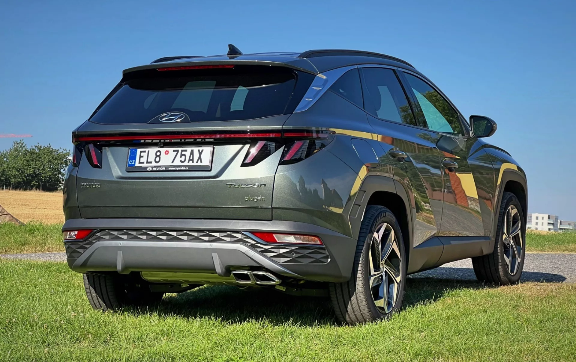 Hyundai Tucson 2020 prikazuje svojo sodobno zasnovo z zadnjim pogledom v treh četrtinah, vključno z LED zadnjimi lučmi, integriranim zadnjim spojlerjem, kovinsko barvo in platišči iz lahkih zlitin na prostem