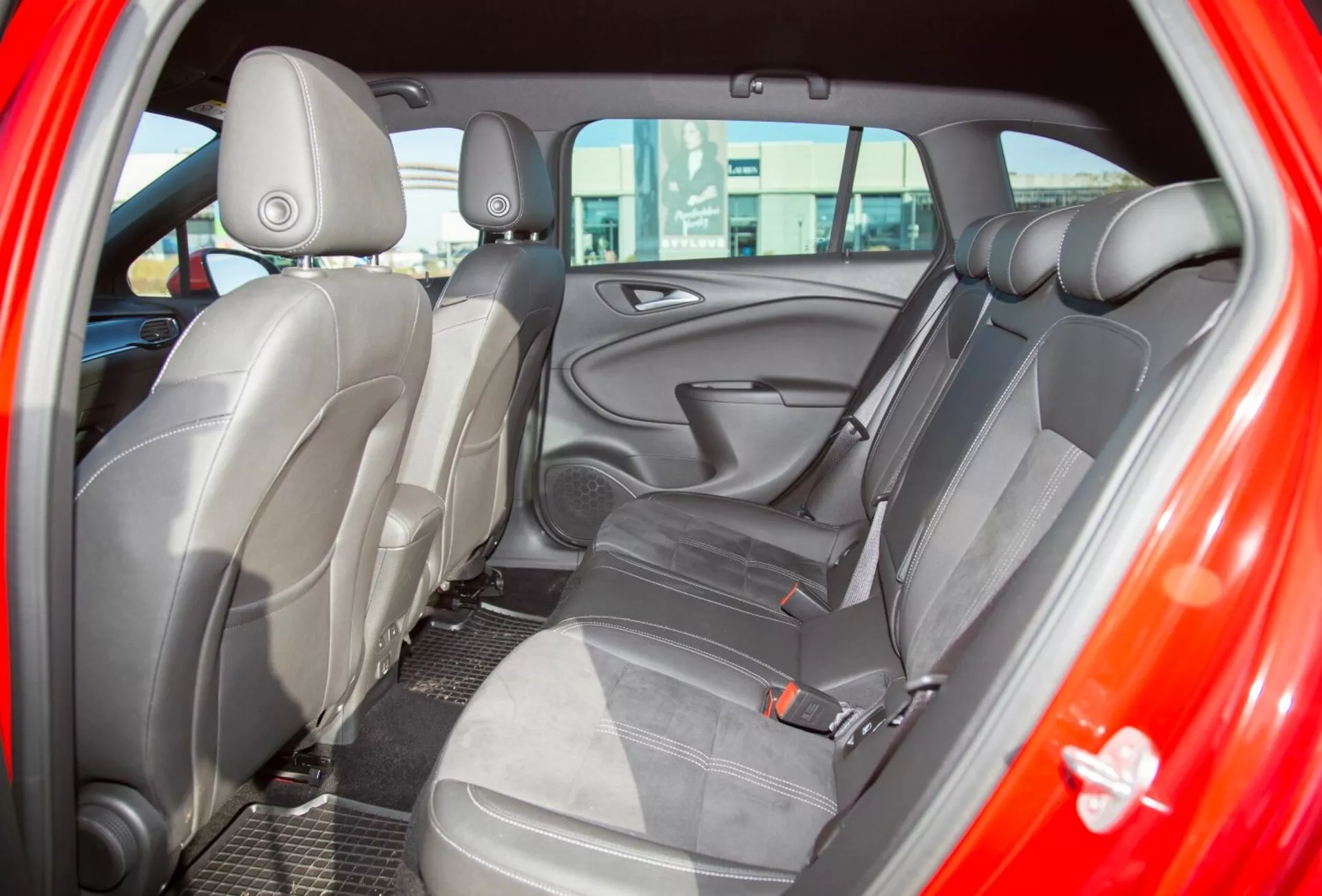 Podroben pogled notranjosti Kia Ceed iz leta 2009, pogled na zadnji sedež skozi zadnja vrata na strani voznika, poudarjajoč oblazinjenje iz dvo-barvne tkanine in ergonomsko oblikovanje sedežev za izboljšano udobje