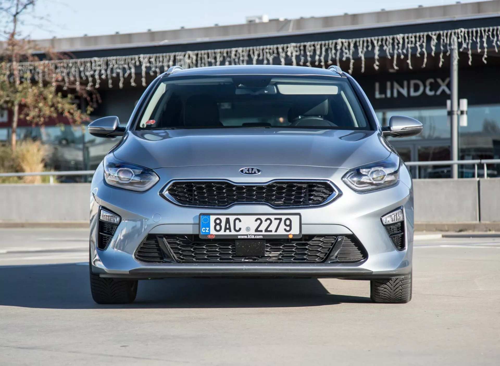 Model Kia Ceed 2009 v kovinski srebrni barvi, pogled od spredaj in strani ob jasnem dnevnem svetlobi, ki prikazuje lita kolesa in aerodinamično oblikovanje