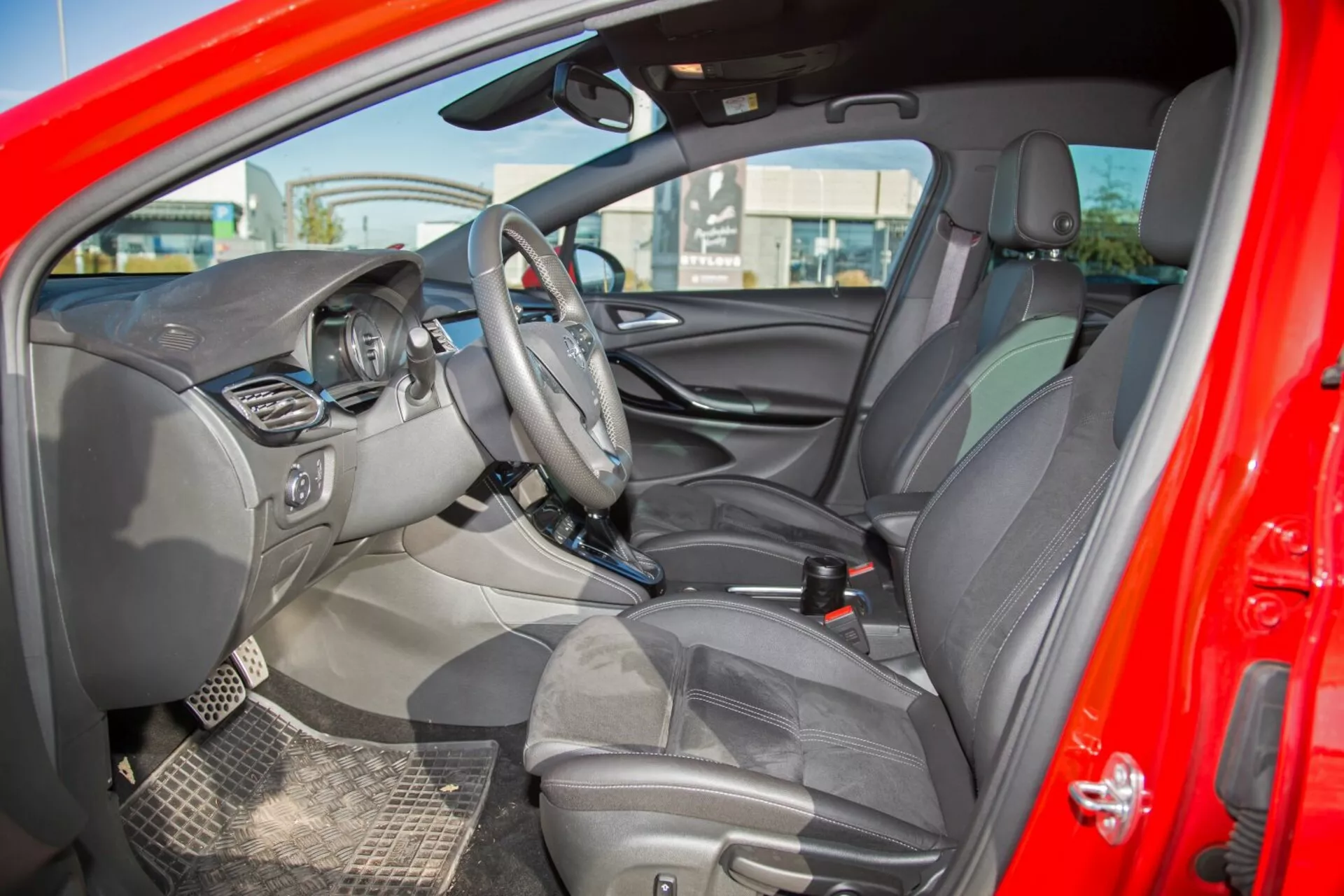 Notranjost Kia cee'd 2009, ki prikazuje volan z upravljalniki, središčni zaslon za infotainmet, vidni instrumentni sklop, središčno konzolo z dodatnimi nadzornimi gumbi, oblazinjene sedeže z naslonjali za glavo, podrobno notranjost vrat s kontrolami, dvobarvno barvno shemo, pogled na vzvratno in voznikovo stransko ogledalo, trpežne talne obloge in signalne luči za zračne blazine, prikazuje celovit dizajn in tehnološko usmerjene značilnosti iz zunanje stranske perspektive