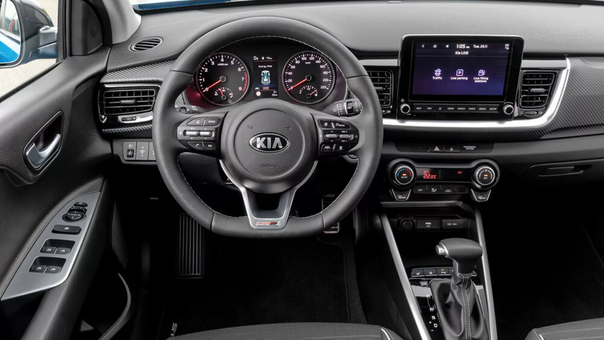 Notranji pogled Kia Stonic 2017 iz perspektive sopotnika, z lastnostmi tristopenjskega volana z vgrajenimi upravljalniki, analognega-digitalnega merilnika, sistema za informacije in razvedrilo na dotik, klimatske kontrole, avtomatskega prenosa in izbiralnika načina vožnje.