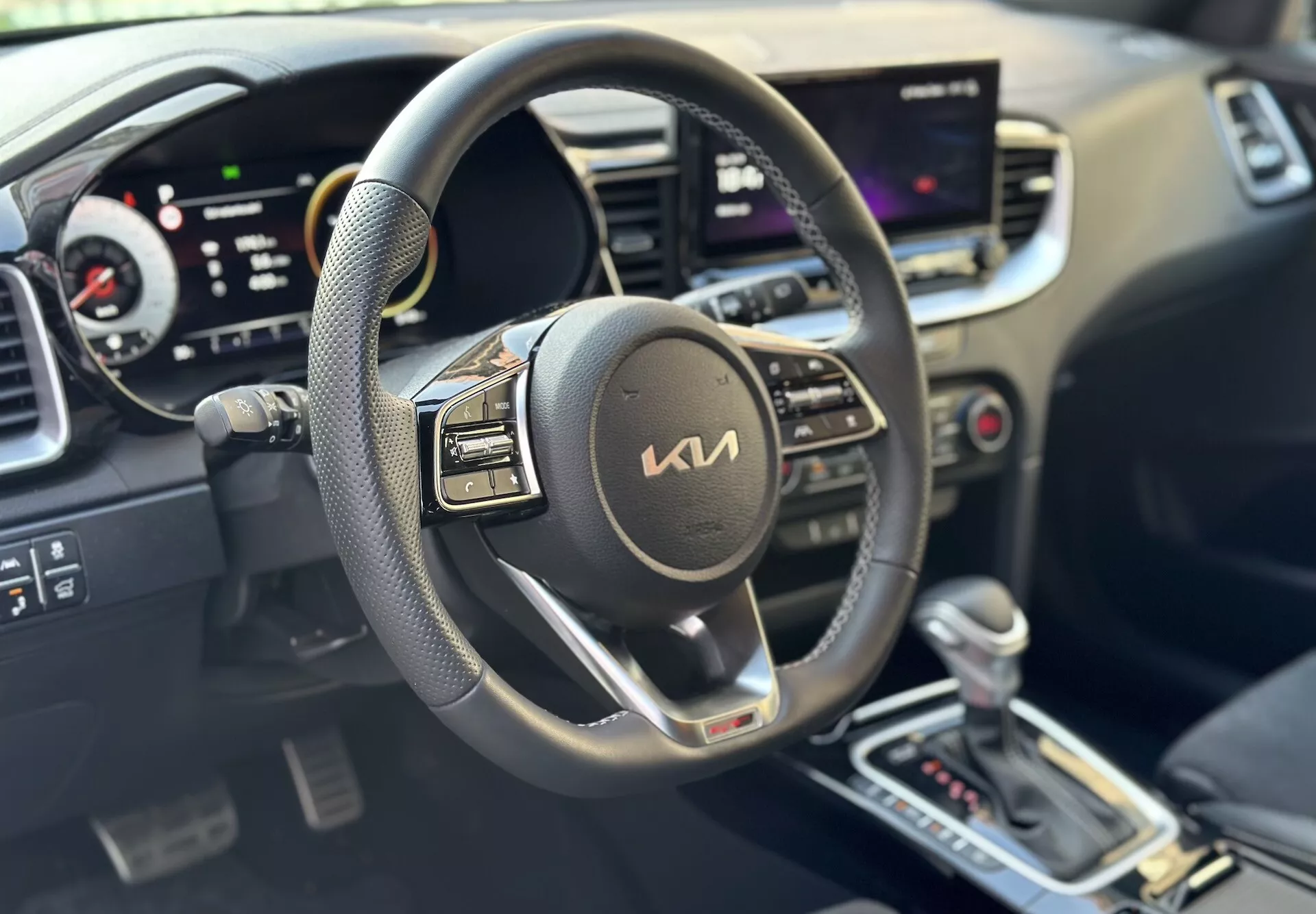 Notranjost Kia Xceed 2022, osredotočena na stran voznika z volanom, digitalno armaturno ploščo in centralnim zaslonom na dotik, kar nakazuje na sodobno tehnologijo in udobje