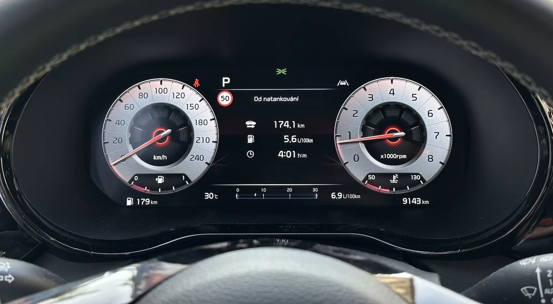 Pogled od blizu na instrumentno ploščo Kia XCeed 2022, ki poudarja merilnik hitrosti, tahometer in digitalni zaslon s kazalcem za parkirni način, prevoženo razdaljo, porabo goriva in skupno število prevoženih kilometrov