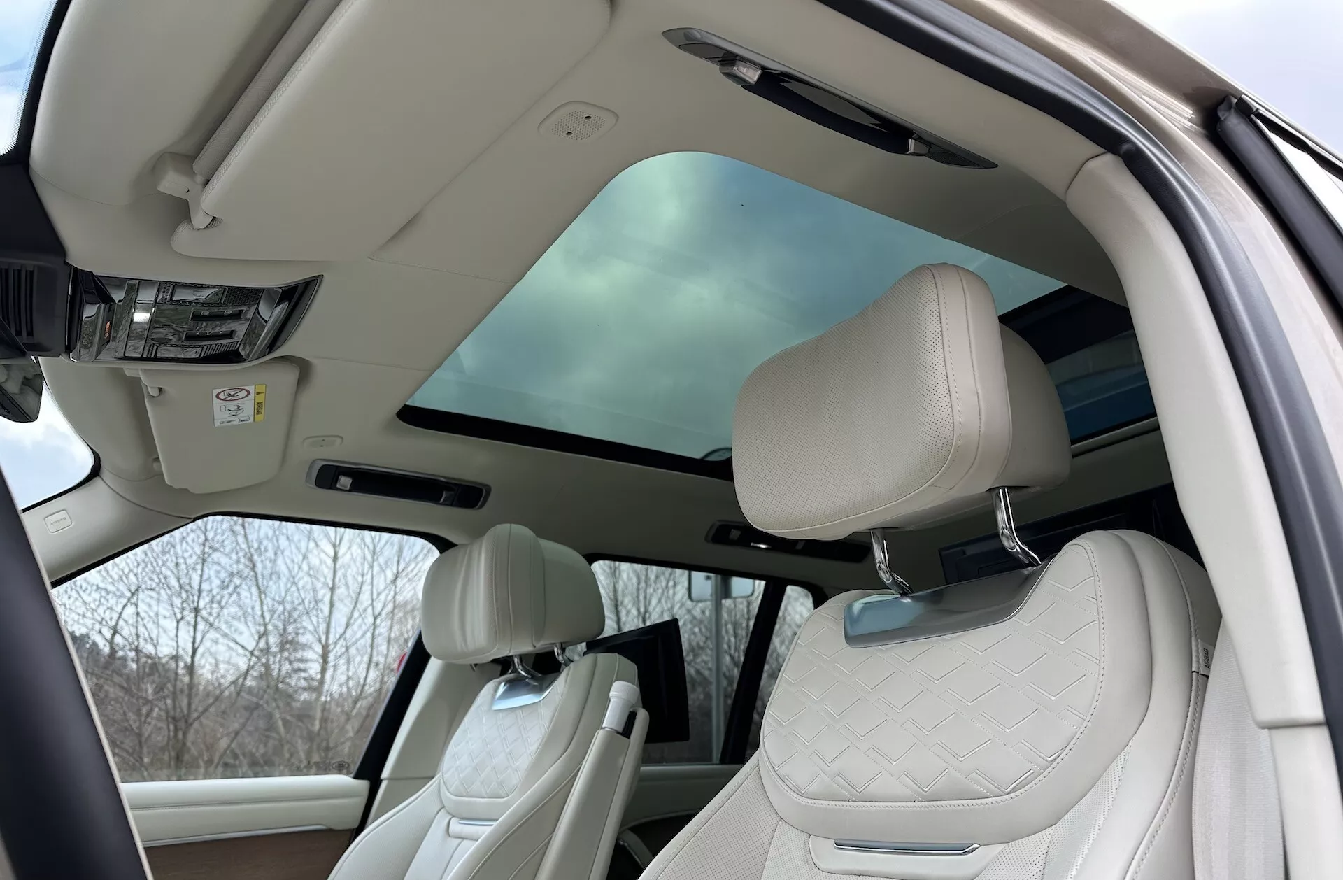 Notranjost Land Rover Range Rover 2021, ki prikazuje luksuzno kabino s panoramsko streho, prešitimi sprednjimi sedeži in naprednimi funkcijami kabine