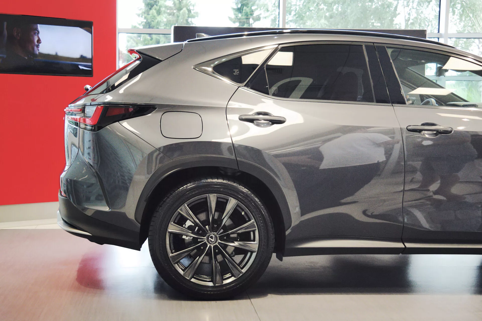 Slika prikazuje zadnji tretjino pogleda na sodoben kompaktni ali srednje velik crossover SUV, s poudarkom na desni strani. Vidne lastnosti vključujejo večkraka aluminijasta platišča, LED zadnje luči, spuščajočo se strešno linijo, zatemnjena zadnja okna, kovinsko barvno lakiranje, ostre karoserijske linije, integriran zadnji spojler, anteno v obliki plavuti morskega psa in spodnje plastične obloge. Oblikovanje vozila nakazuje športen, aerodinamičen profil, primeren za razprave o avtomobilskem oblikovanju, tehnologiji in lastnostih.