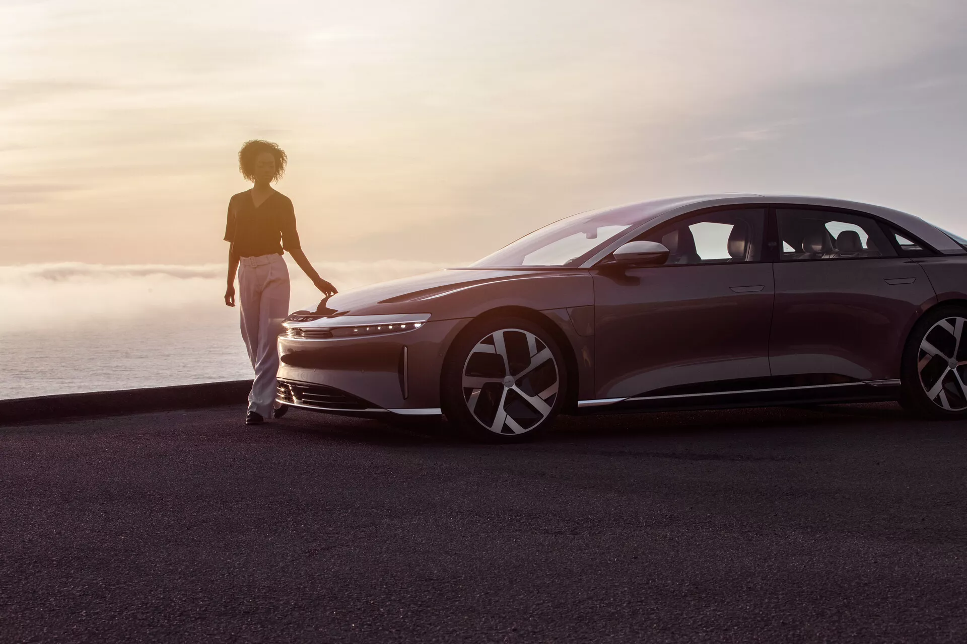 Lucid Air 2022 (1. generacija) električna luksuzna limuzina z elegantnim zunanjim dizajnom, modernimi sprednjimi lučmi in zadnjimi lučmi, stiliziranimi kolesi in napredno tehnologijo za avtonomno vožnjo.