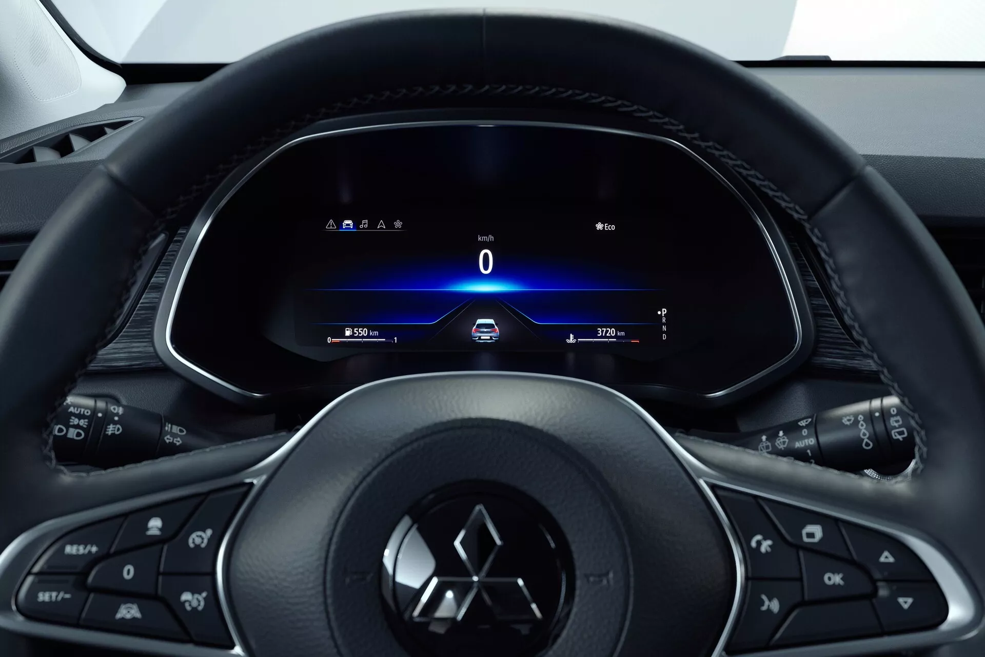Pogled v notranjost Mitsubishi ASX 2023 (2. generacija) s sedeža voznika, ki se osredotoča na večfunkcijski volan s tremi kraki z gumbi za medije, telefon, tempomat in s proizvajalčevim emblemom. Za njim je popolnoma digitalni prikazovalnik instrumentov, ki prikazuje hitrost 0 km/h, smerokaze, čas in števec prevoženih kilometrov. Slog kokpita nakazuje na zasnovo, osredotočeno na voznika, s tanko in moderno estetiko, ki poudarja tehnologijo ter enostaven dostop do informacij in nadzora vozila.