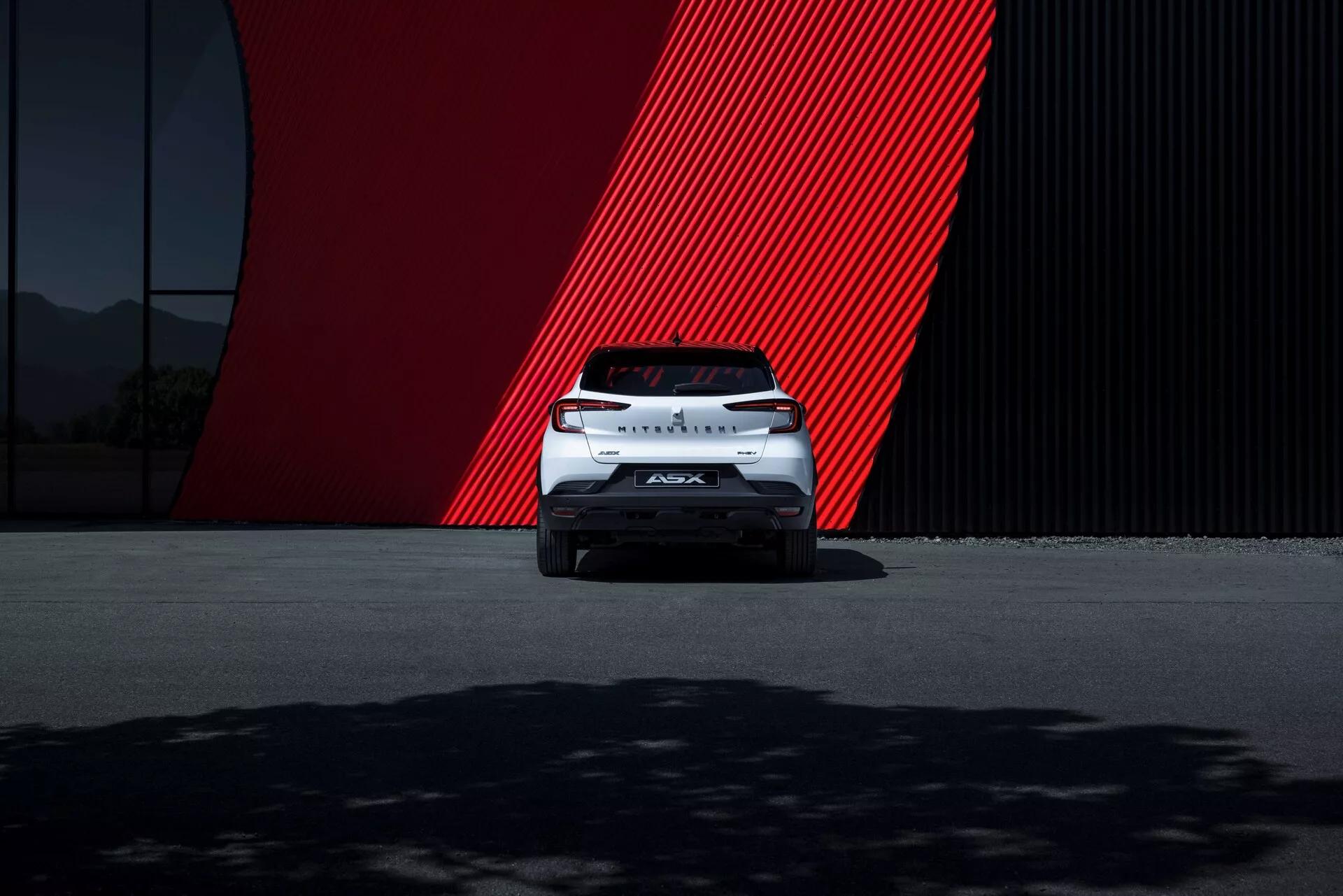 Stranski pogled Mitsubishi ASX 2023 druge generacije, ki prikazuje eleganten dizajn, sodobne LED žaromete in elegantna lita platišča.