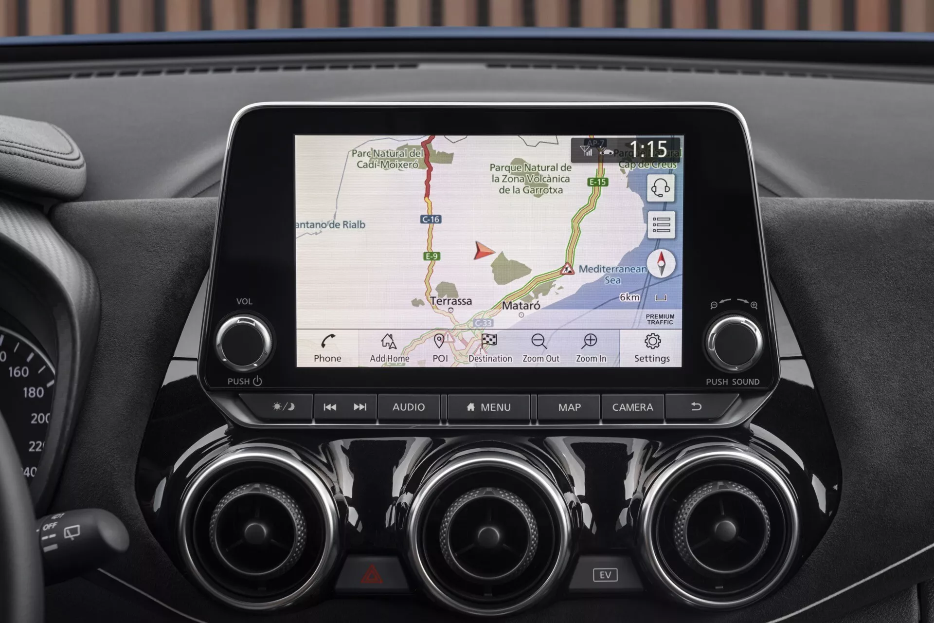 Podroben pogled na prikazovalnik in centralno armaturno ploščo Nissan Juke F16 letnik 2019 z GPS navigacijo, povezljivostjo s telefonom, zračniki in kontrolnimi gumbi za napredno tehnologijo in udobje