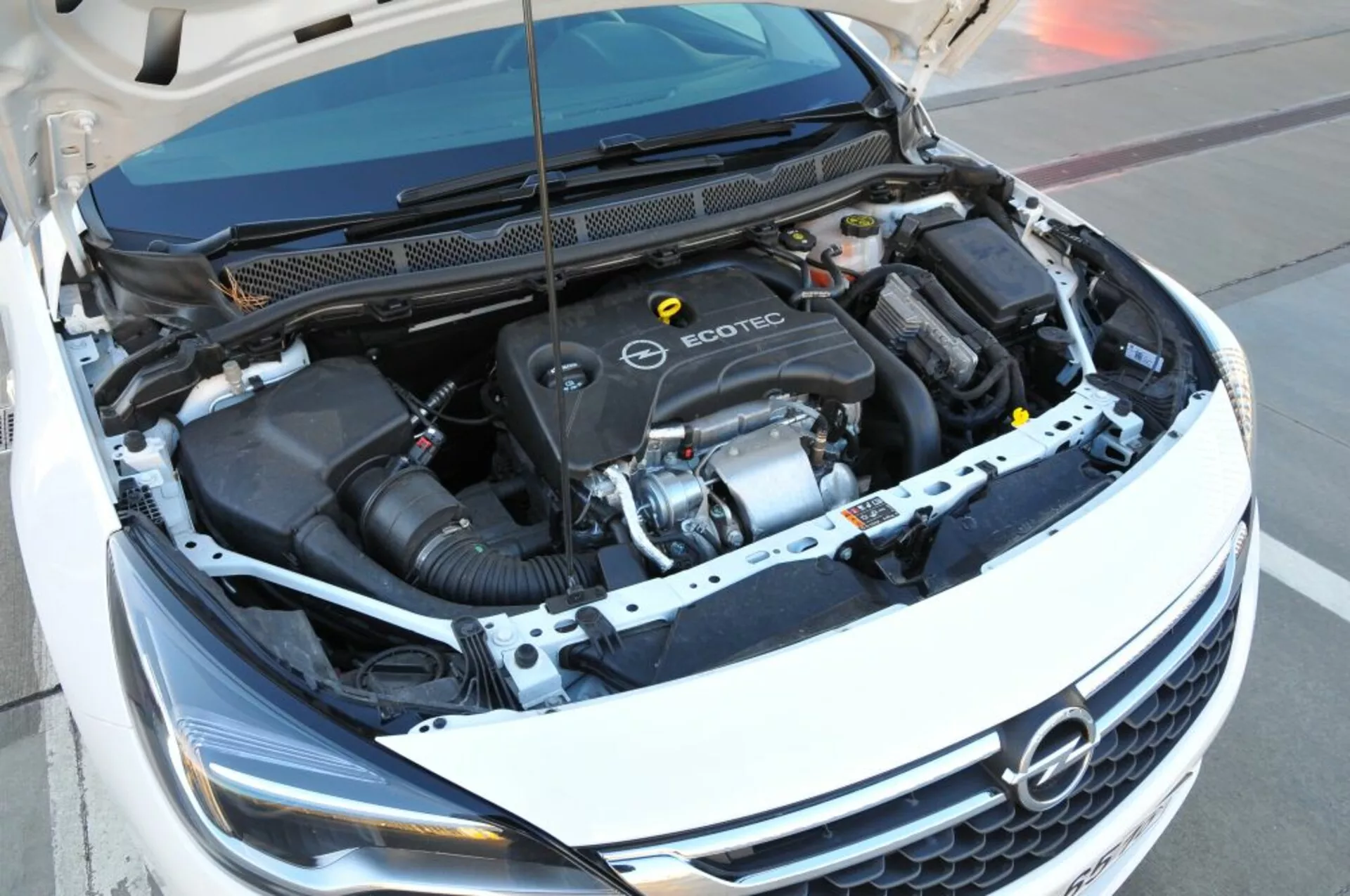 Pogled od zgoraj na motorjni prostor Ecotec vozila Opel Astra 2005 prikazuje motor, cev za dovod zraka in različne komponente