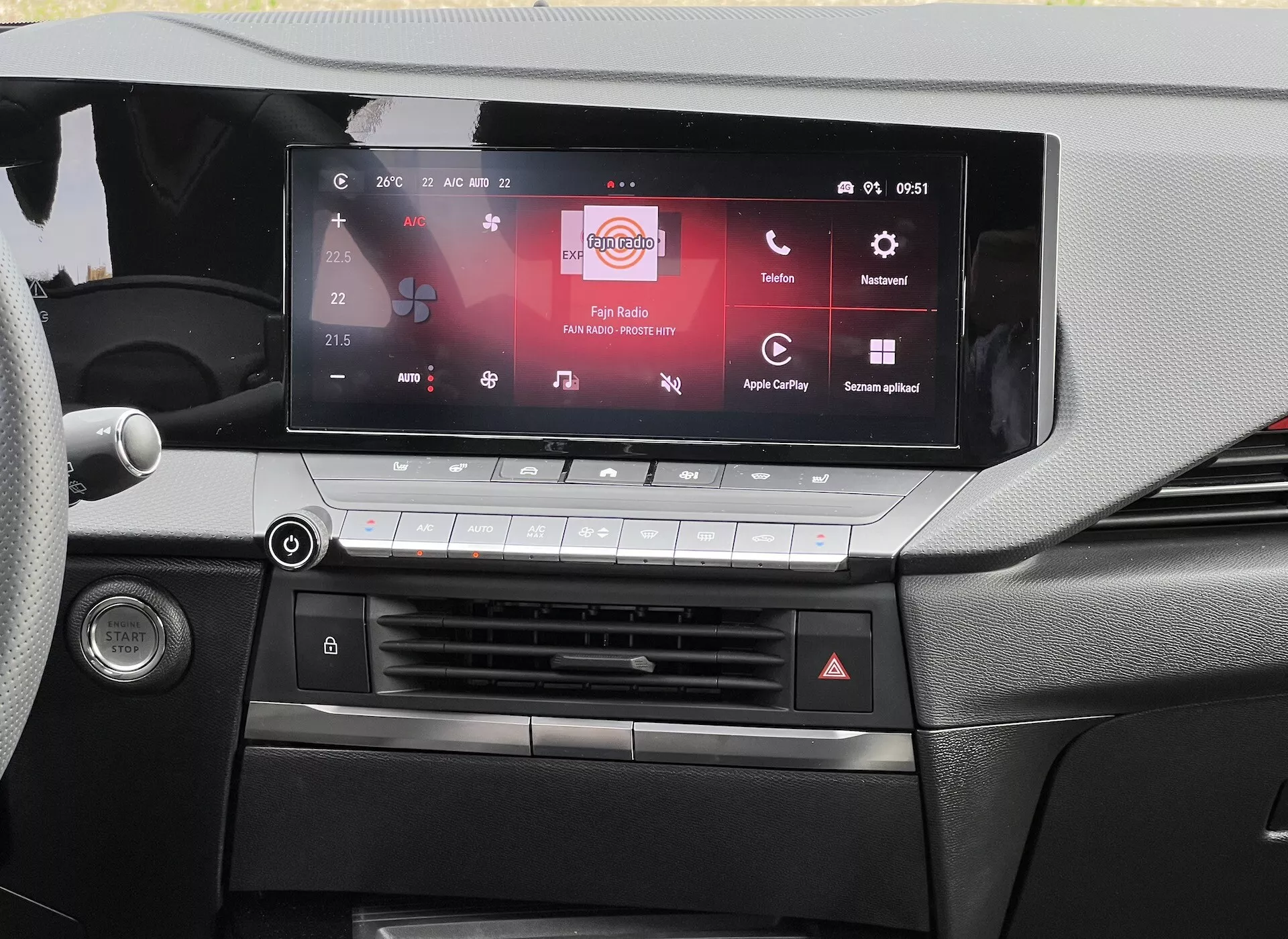 Pogled na armaturno ploščo Opel Astra 2022, ki poudarja zaslon na dotik infotainment sistema, združljiv z Apple CarPlay in Android Auto, sistem za nadzor klime in podroben dizajn kabine
