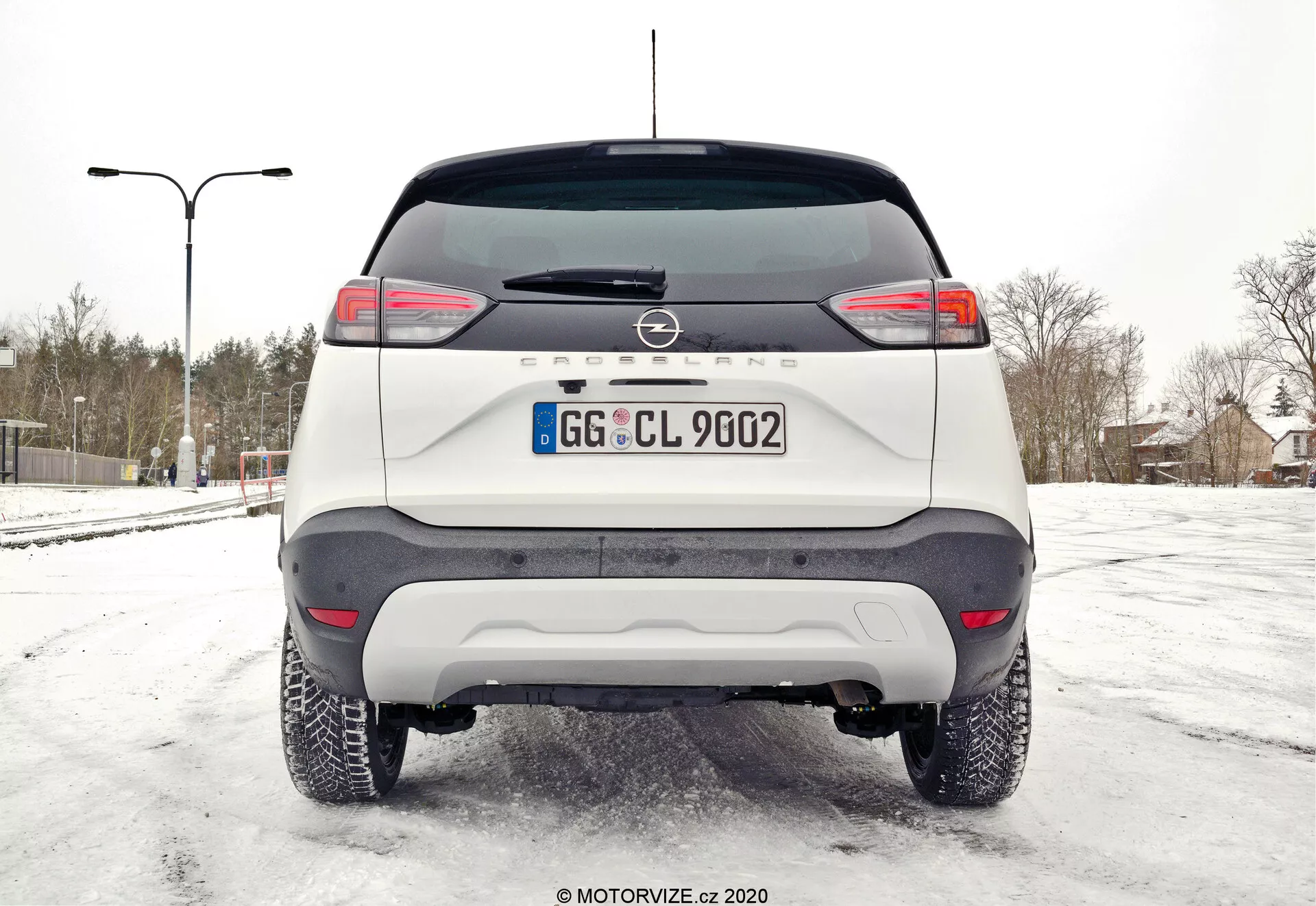 Stranski pogled na Opel Crossland 1.2 iz leta 2021 v osupljivem mestnem okolju, ki izpostavlja njegovo elegantno zasnovo in sodobne funkcije