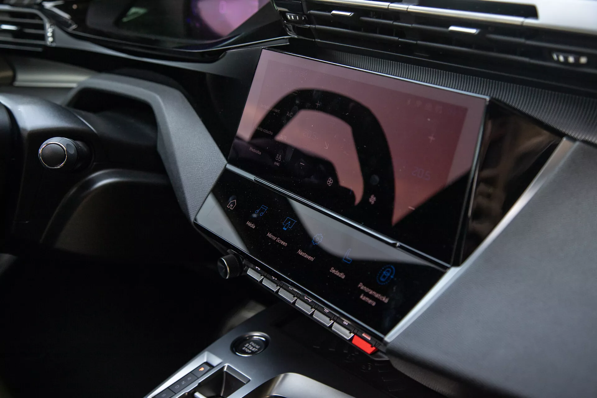 Notranjost Peugeota 408 letnik 2023 s prikazom središčne konzole in naprednega sistema za informacije in zabavo z zaslonom na dotik, gumbi za nadzor klime in elegantnimi oblikovalskimi poudarki
