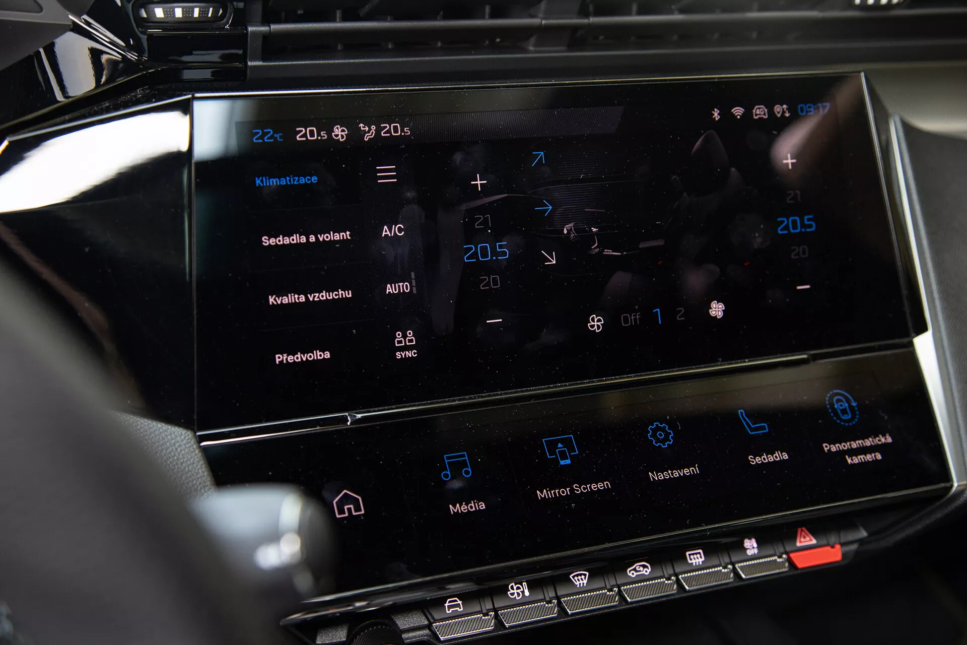 Sredinska konzola Peugeot 408 2023, ki prikazuje zaslon na dotik infotainment sistema in vmesnik za nadzor klime z nastavitvami temperature in naprednimi funkcijami