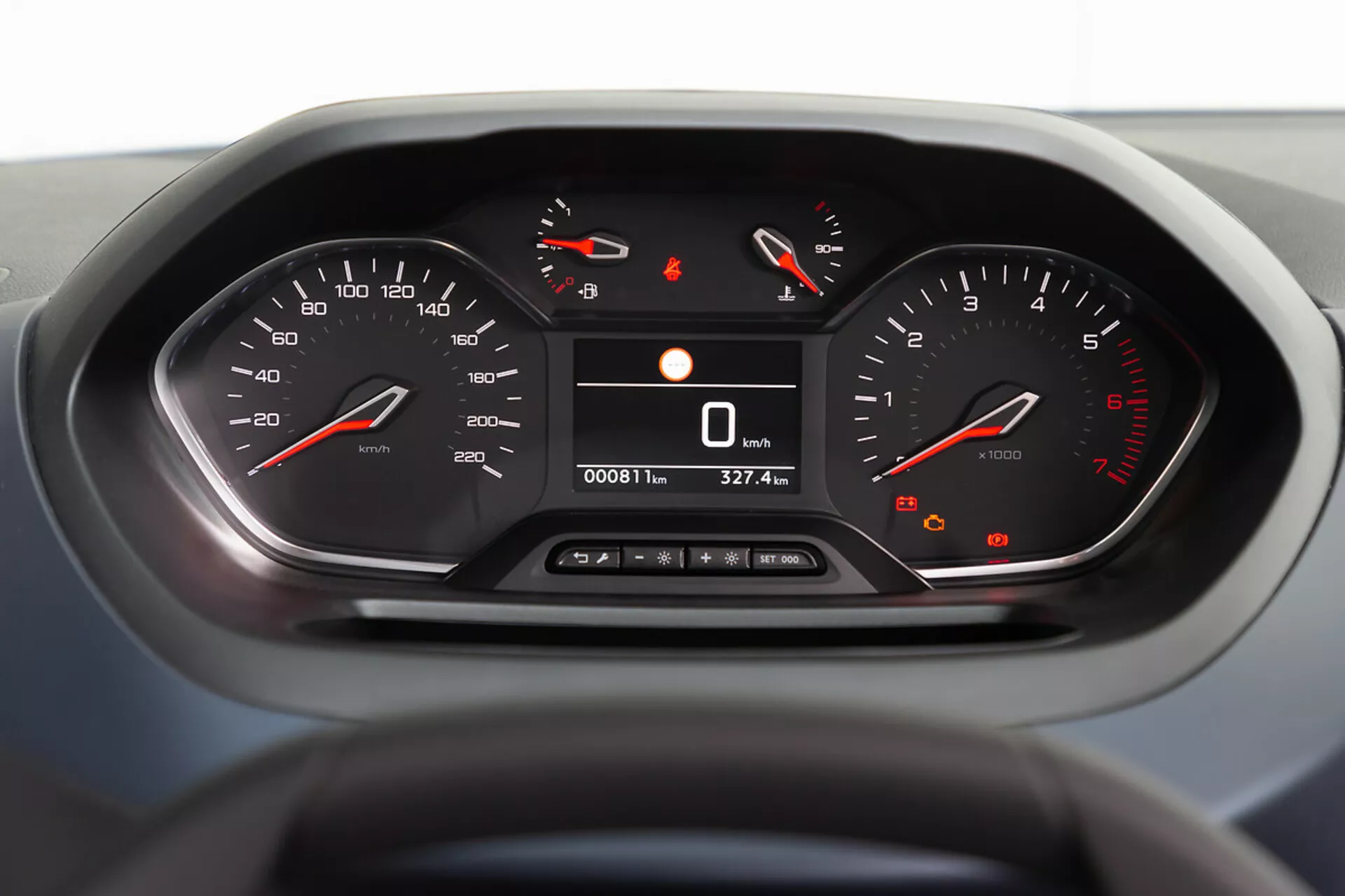 Podroben pogled na instrumentno ploščo Peugeota Rifter 2018 z osvetlitvijo analognega hitrostomera in tahometra, digitalnih odčitkov hitrosti in števca kilometrov, osredotočen na notranjo tehnologijo in oblikovanje iz perspektive voznika