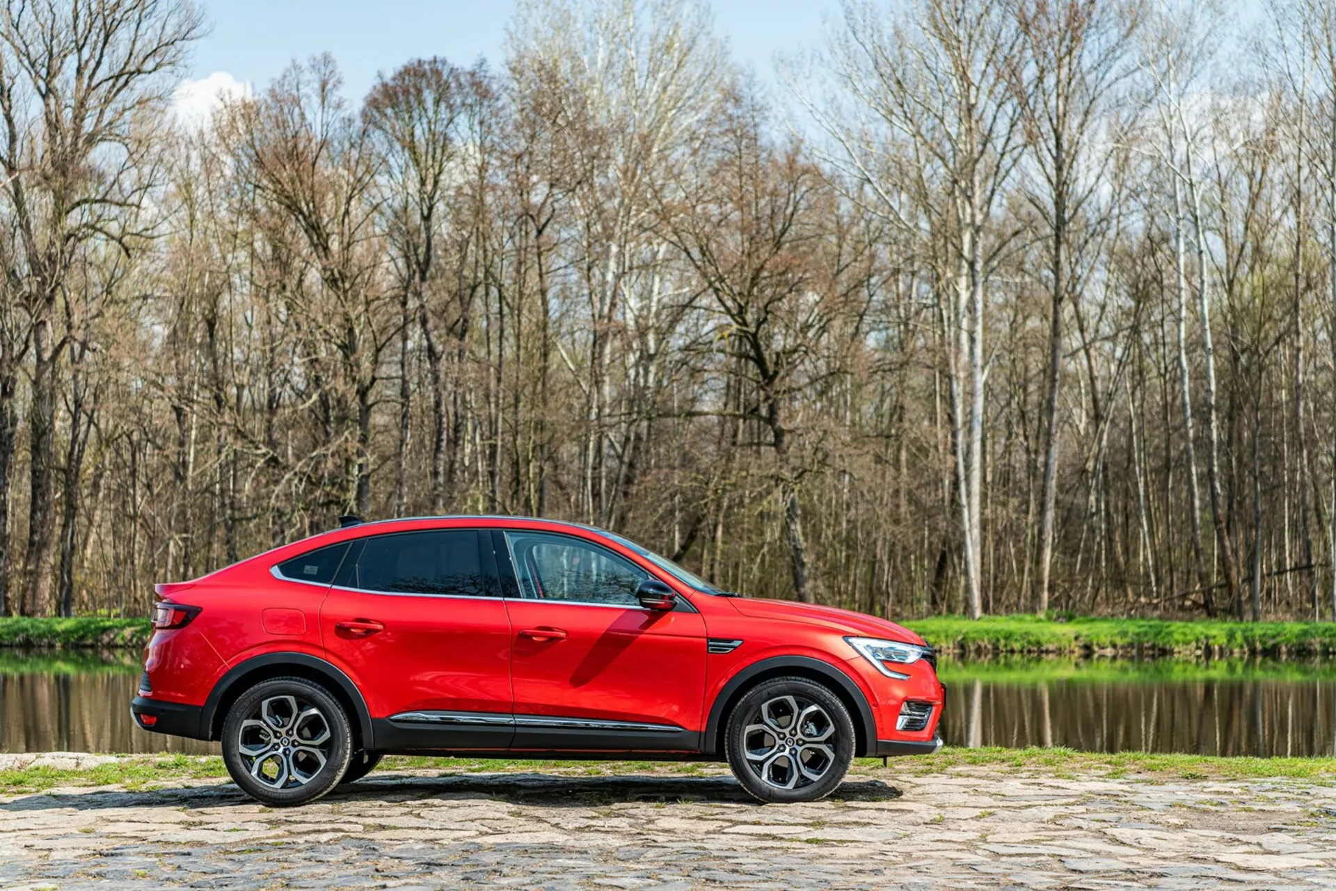 Prednji pogled na Renault Arkana 2021 v elegantnem, sodobnem dizajnu z elegantnimi LED žarometi in drzno, dinamično masko, ki prikazuje športno, vendar prefinjeno podobo.